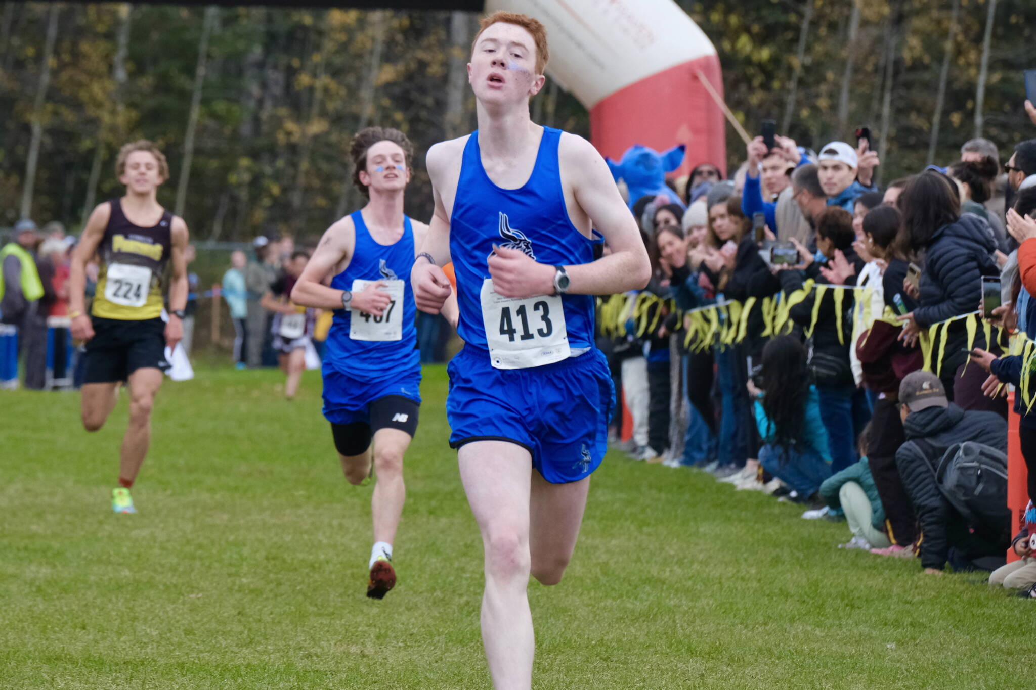 Petersburg junior Gaje Ventress (413) leads classmate Alex Holmgrain (407) to the finish of the Division III boys 2024 ASAA cross-country running state championships Saturday on the Bartlett High School Trails in Anchorage. (Klas Stolpe / Juneau Empire)