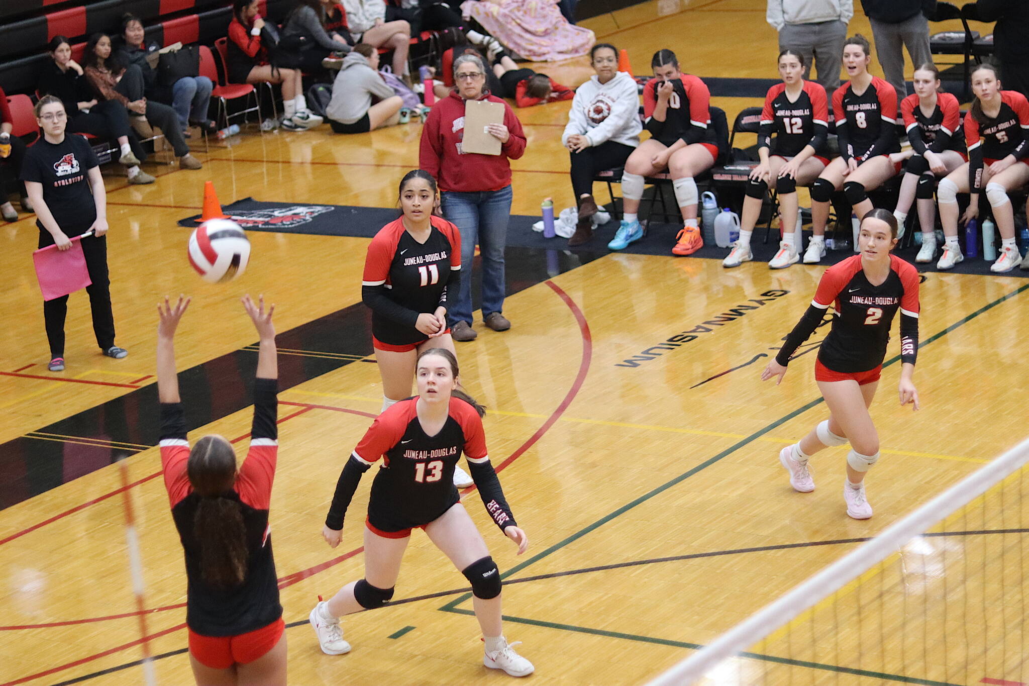 June Troxel (left), a sophomore for Juneau-Douglas High School: Yadaa.at Kalé’s varsity volleyball team, sets up a teammate during Saturday’s game against Mountain City Christian Academy in an elimination game of the Juneau Invitational Volleyball Extravaganza at JDHS. Pictured on the court with Troxel are Amelia Elfers (13), Lavinia Ma’ake (11) and Braith Dihle (2). Head Coach Jody Levernier is standing behind them holding a clipboard. (Mark Sabbatini / Juneau Empire)