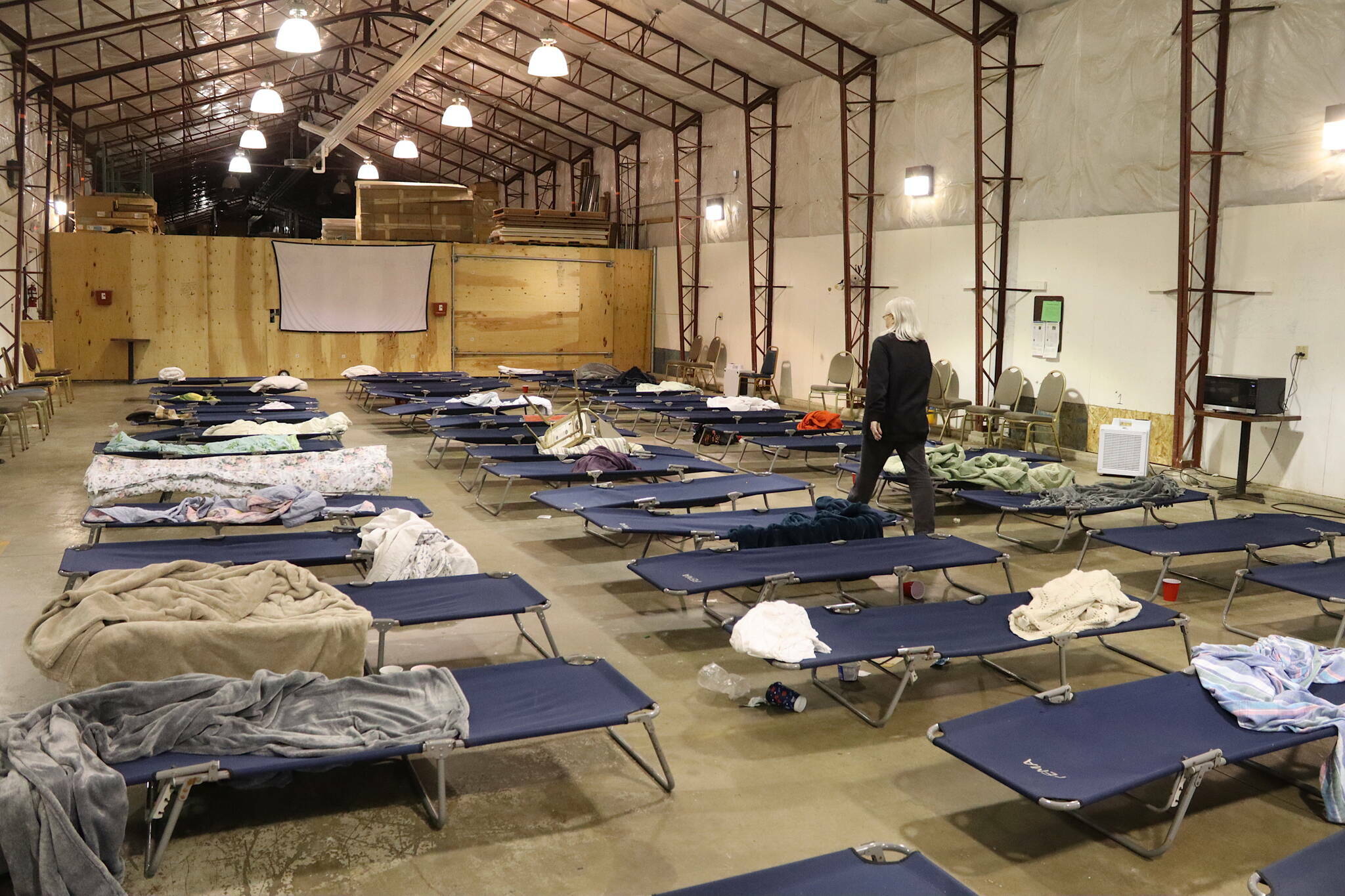 Jackie Bryant, director of the city’s cold-weather emergency shelter during its first season, inspects cots after people staying there depart on Wednesday, March 27, 2024. (Mark Sabbatini / Juneau Empire file photo)