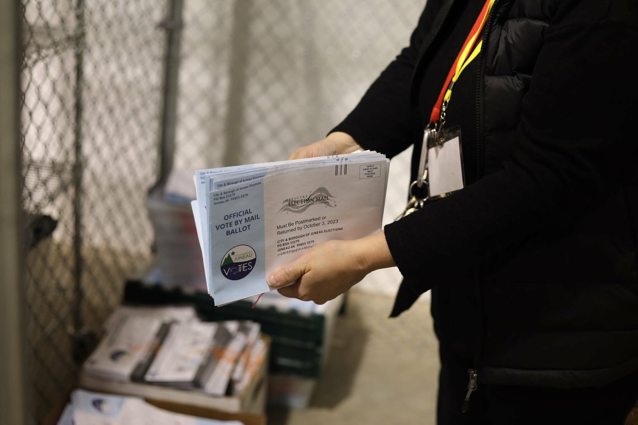 A city election work handles envelopes from the 2023 municipal election at the City and Borough of Juneau Ballot Processing Center. (Clarise Larson / Juneau Empire file photo)