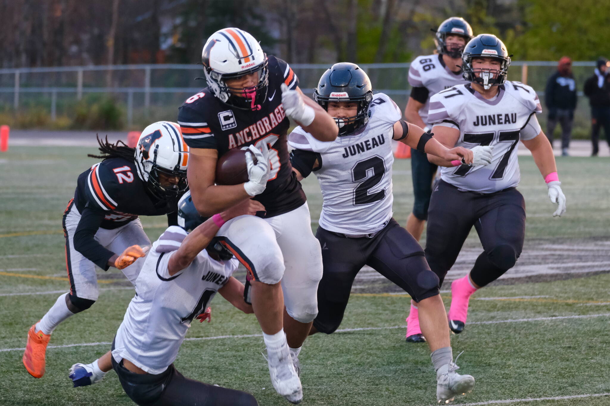 Juneau Huskies senior Jayden Johnson (4), senior Hayden Aube (2) and junior Ricky Tupou (77) try to bring down West Anchorage senior Zephaniah Sailele (6) during the Huskies 20-13 loss to the Eagles in the 2024 ASAA State Football Playoffs on Saturday at West Anchorage’s Nest on Hillcrest. (Klas Stolpe/Juneau Empire)