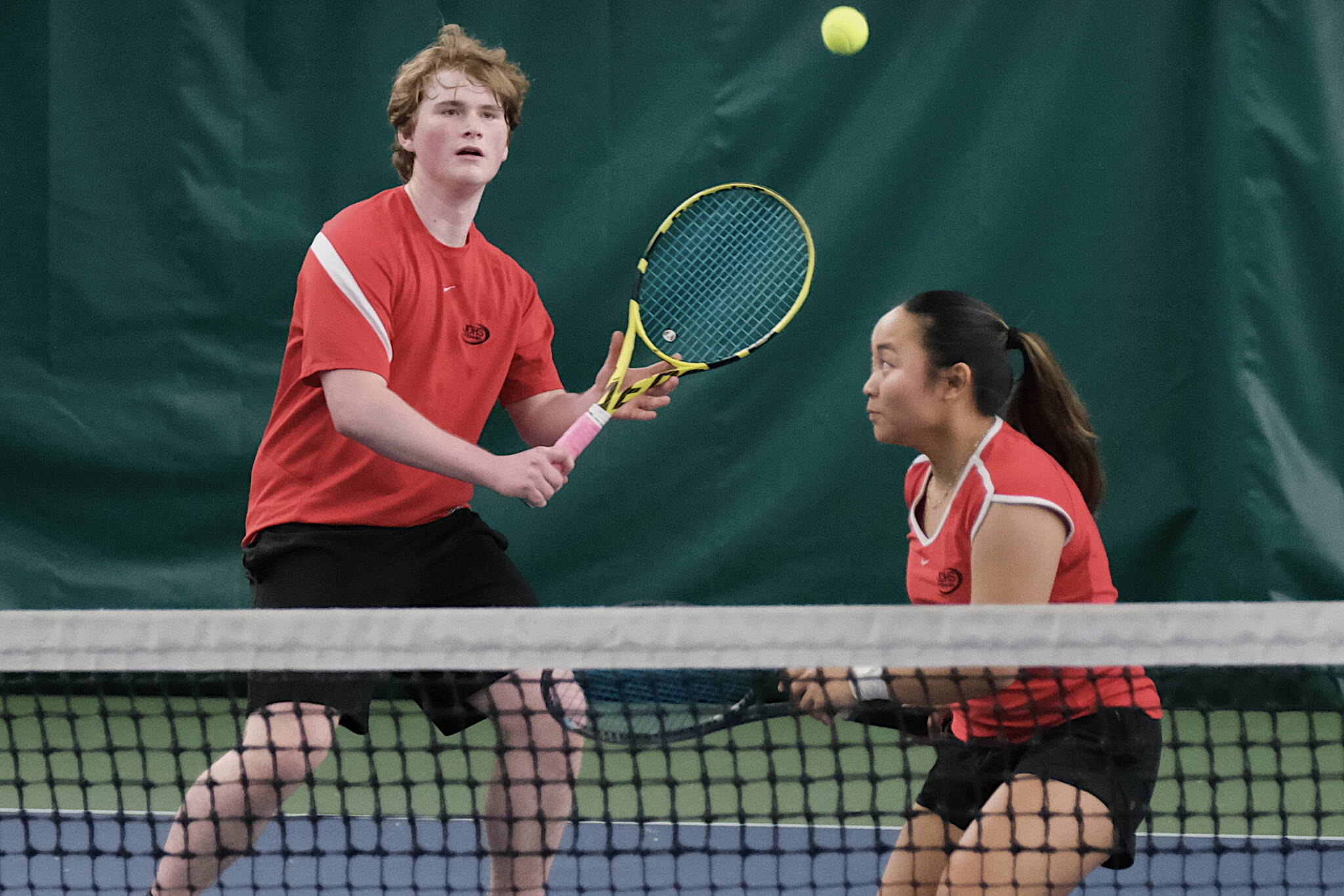 Juneau-Douglas High School: Yadaa.at Kalé senior Alex Rehfeldt and senior Milina Mazon play a ball during their mixed doubles match for the 2024 ASAA Tennis Championship on Saturday at Anchorage’s Alaska Club. (Klas Stolpe / Juneau Empire)