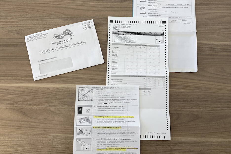 These materials are mailed to Alaska voters who request absentee ballots. Clockwise, from the top right: The envelope from the Alaska Division of Elections, the return envelope, the ballot and instructions. (Andrew Kitchenman/Alaska Beacon)