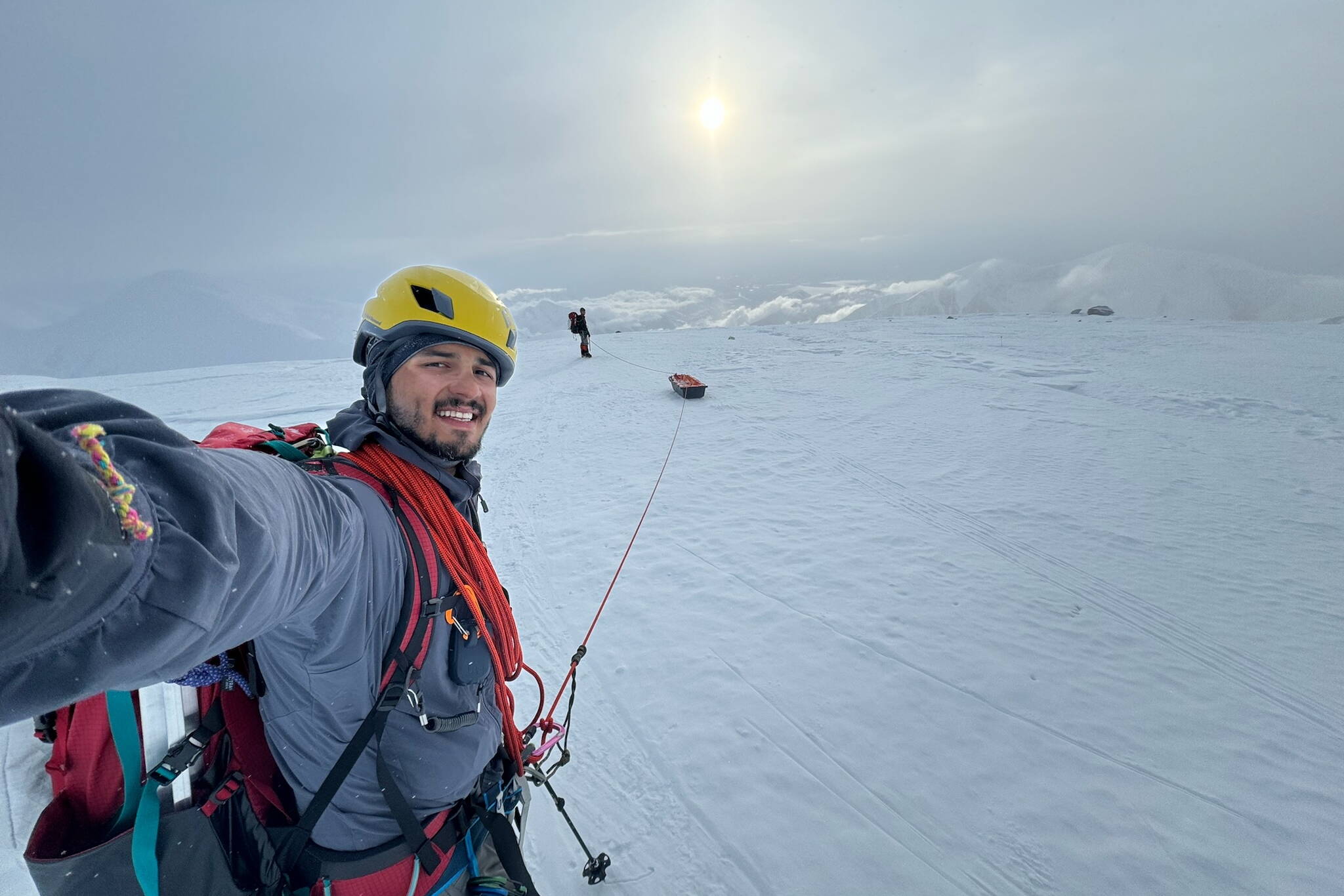 Roger Jaramillo walks on crampons while roped to a sled and his partner Matthew Crisafi-Lurtsema. The pair climbed Denali and sampled microplastics along their route in June of 2024. (Photo by Roger Jaramillo)