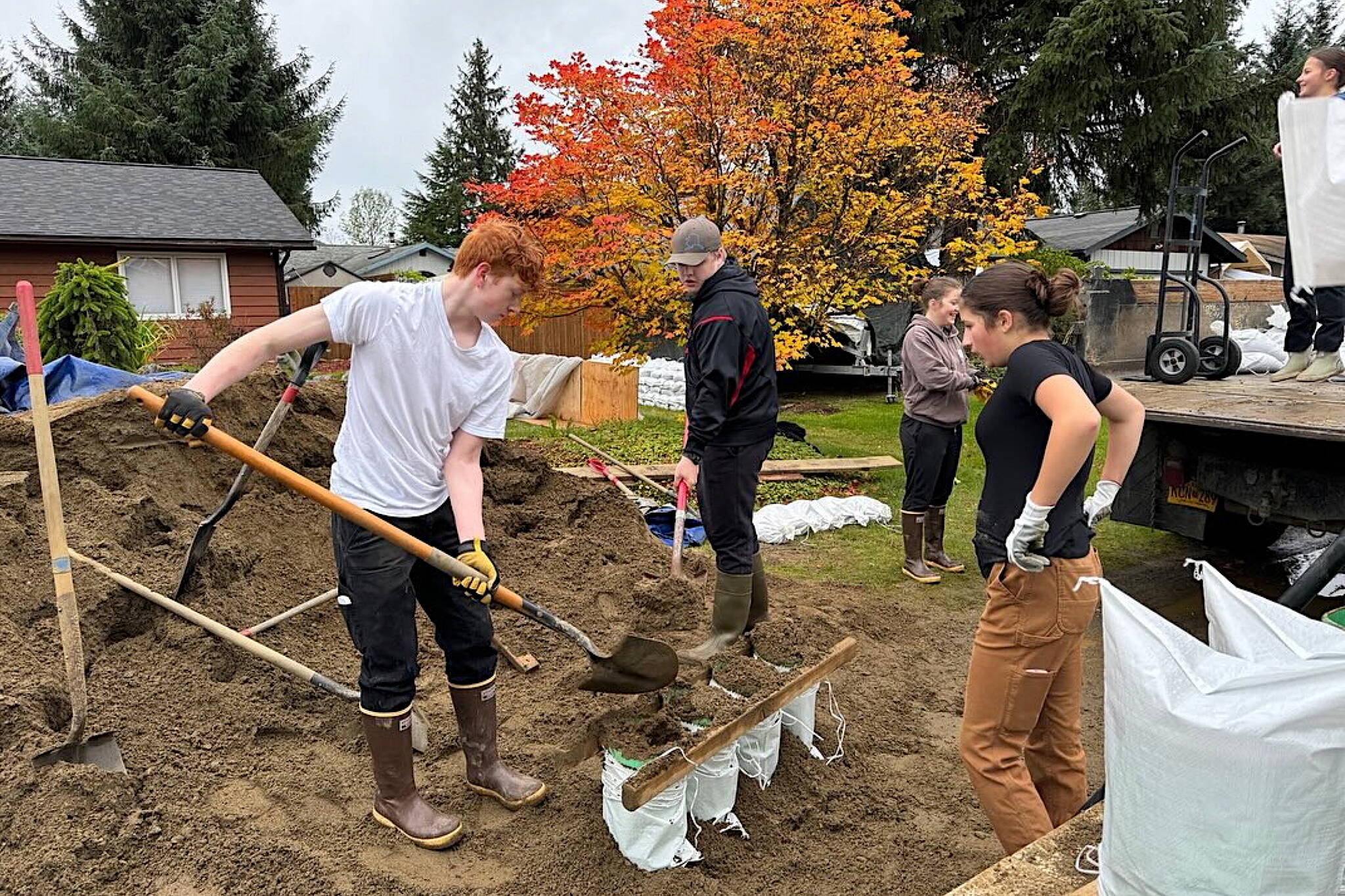 Members of the Juneau-Douglas High School: Yadaa.at Kalé hockey team help Mendenhall Valley residents affected by the record Aug. 6 flood fill more than 3,000 sandbags earlier this month. (JHDS Hockey photo)