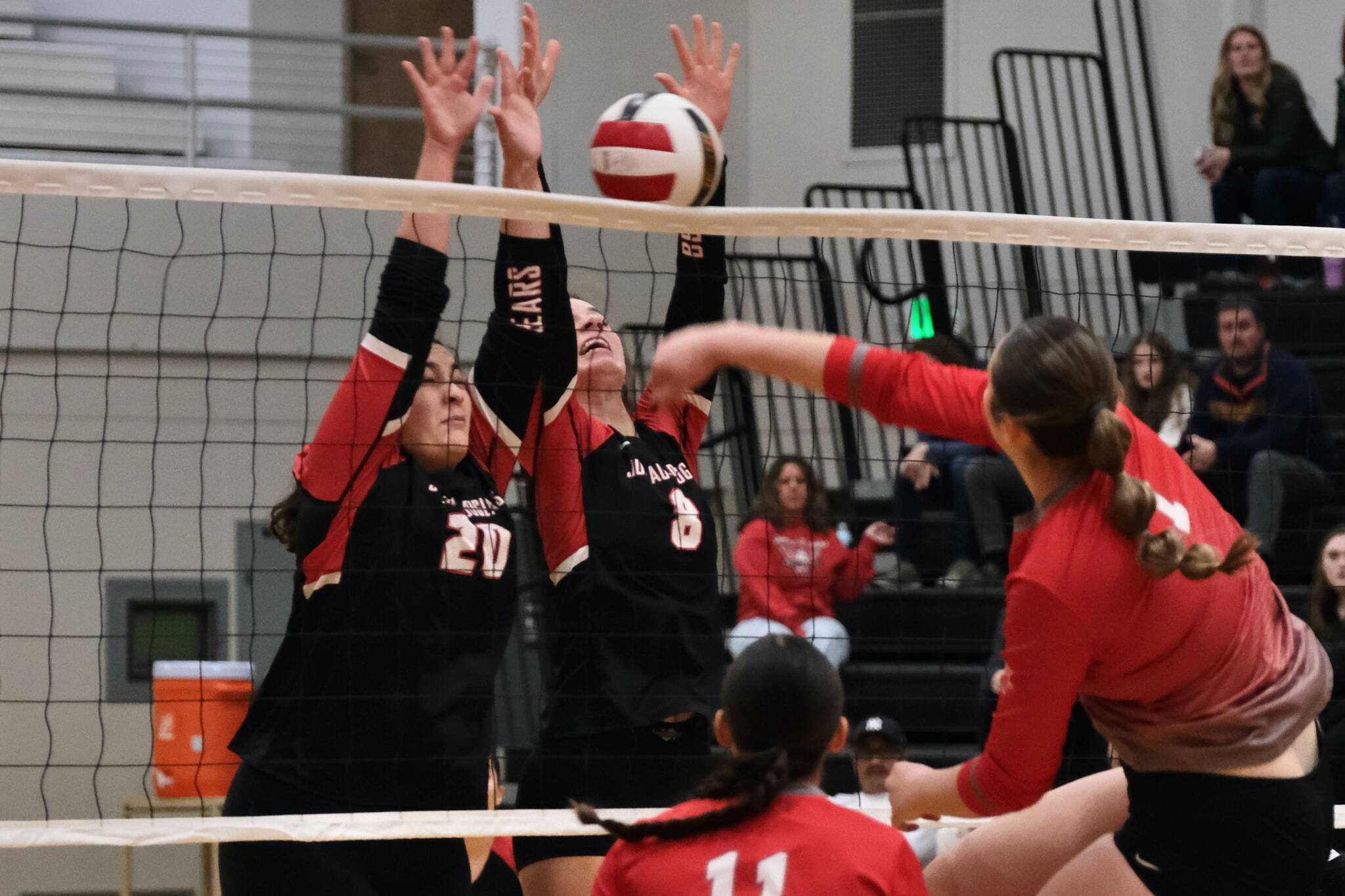 Juneau-Douglas High School: Yadaa.at Kalé junior Natalia Harris (20) and senior Evelyn Richards (8) block a kill by Wasilla senior Layla Hays during the Crimson Bears’ three-set loss to the visiting Warriors on Saturday at the George Houston Gymnasium. (Klas Stolpe/Juneau Empire)