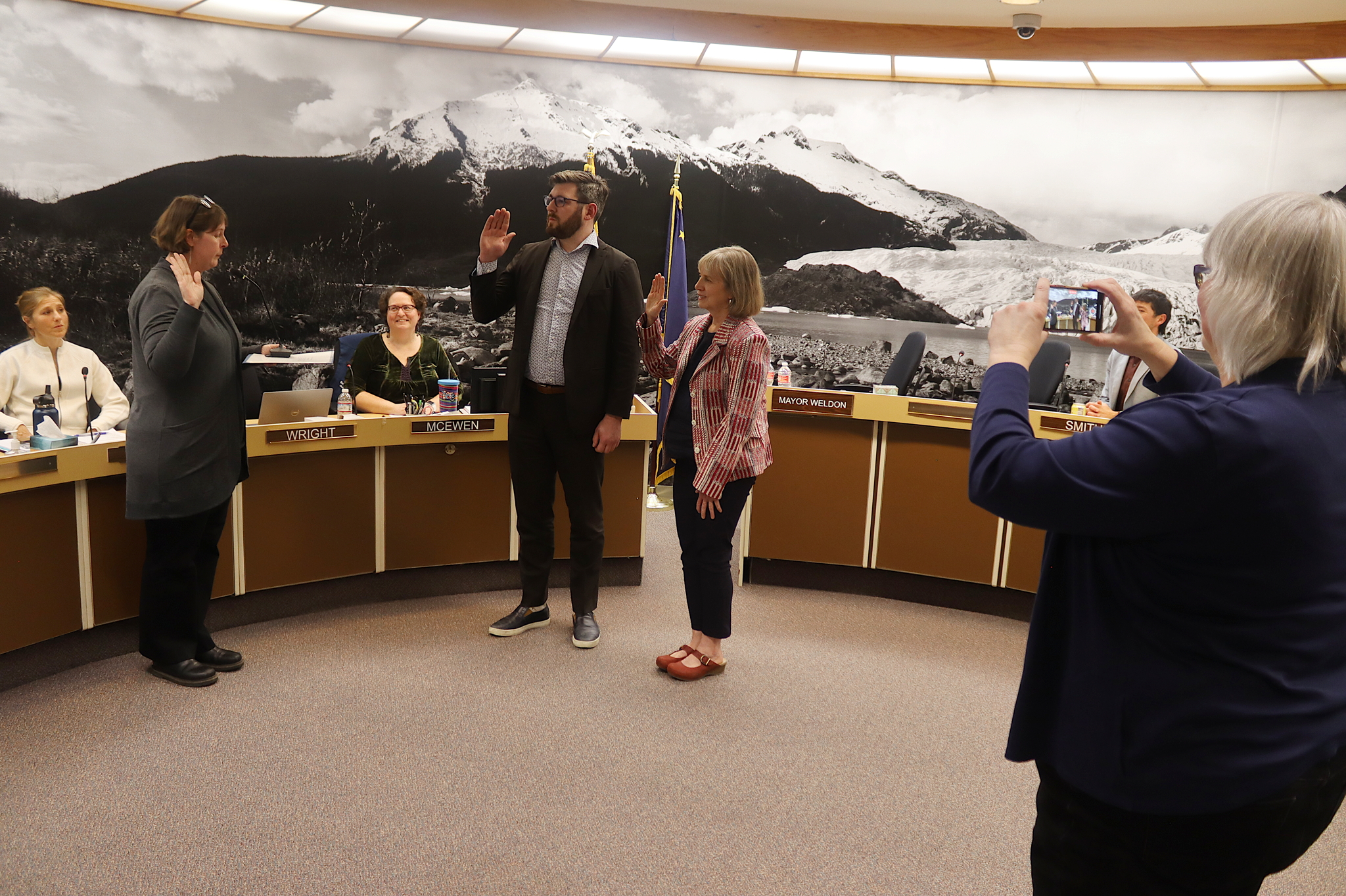 Municipal Attorney Emily Wright (left) swears in newly elected Juneau Assembly members Neil Steininger and Maureen Hall as newly reelected Mayor Beth Weldon takes a photo during an Assembly meeting Monday night at City Hall. (Mark Sabbatini / Juneau Empire)