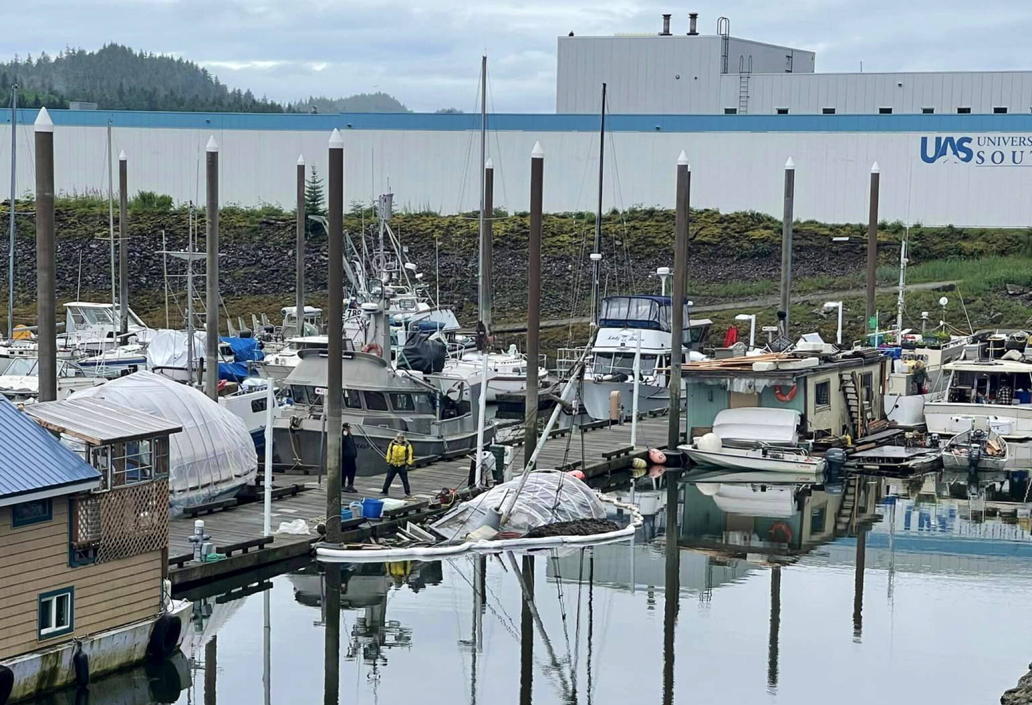 City harbor staff inspect a sunken vessel in Harris Harbor on July 11. An increase in fees for uninsured vessels is being proposed in part to pay the cost of salvaging and removing an increasing number of such vessels without insurance. (Juneau Harbors photo)