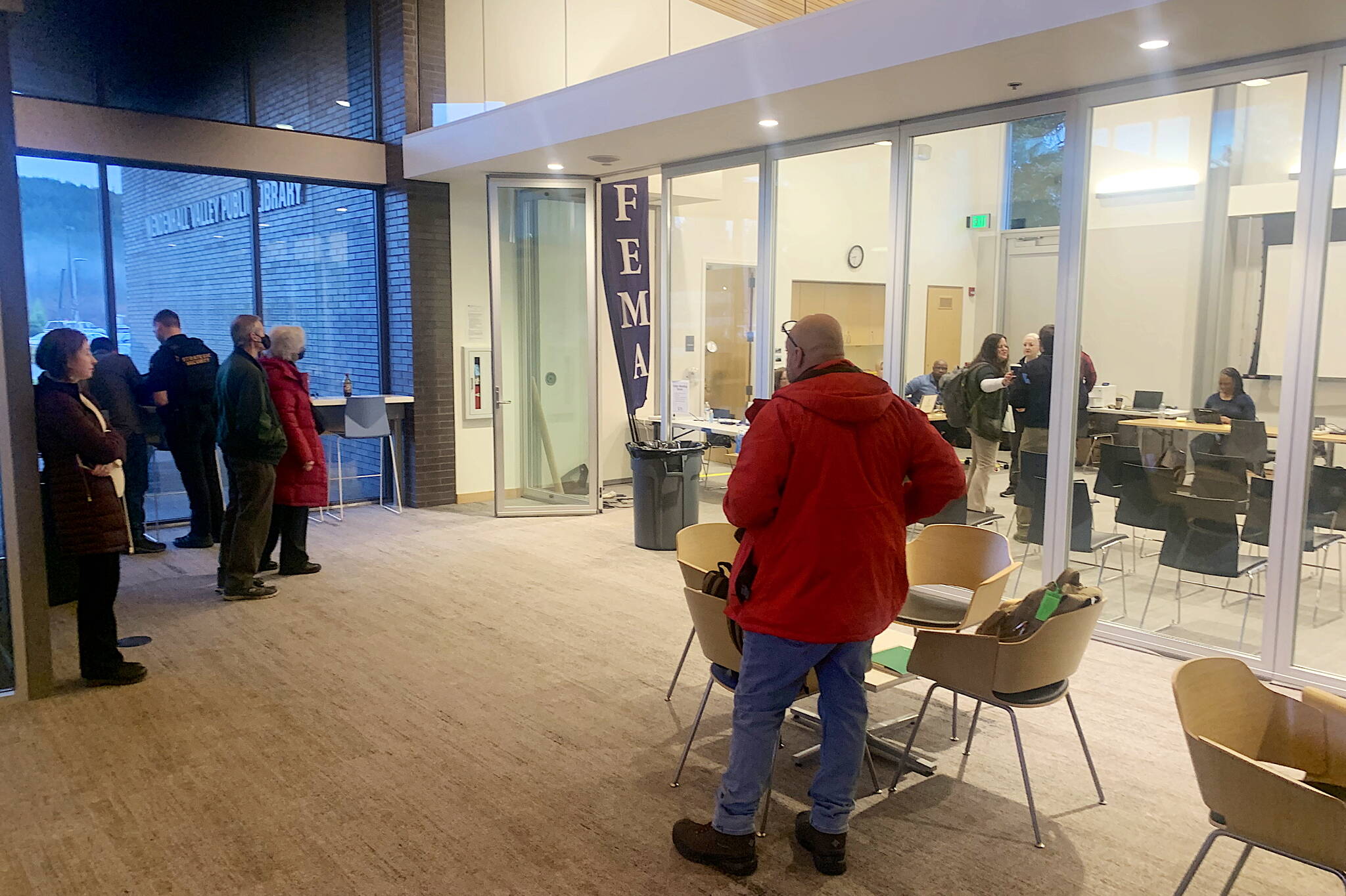 People arrive at a Federal Emergency Management Agency disaster recovery center set up in a meeting room at the Mendenhall Valley Public Library on Wednesday. The center is to provide assistance to people affected by record flooding from Suicide Basin in August. (Mark Sabbatini / Juneau Empire)