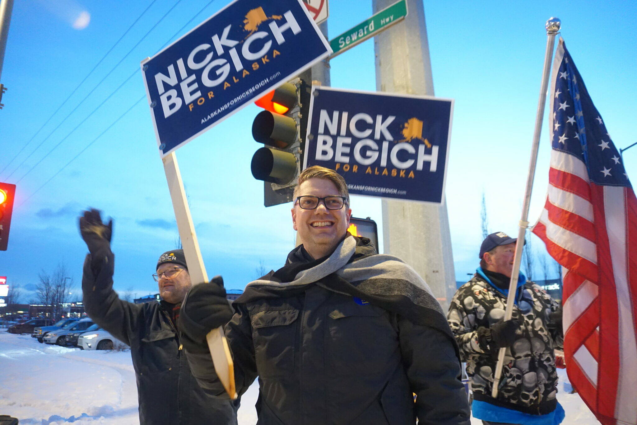 Republican U.S. House candidate Nick Begich and his supporters wave campaign signs at the corner of the Seward Highway and Northern Lights Boulevard on Nov. 4, 2024, the day before Election Day. (Yereth Rosen/Alaska Beacon)