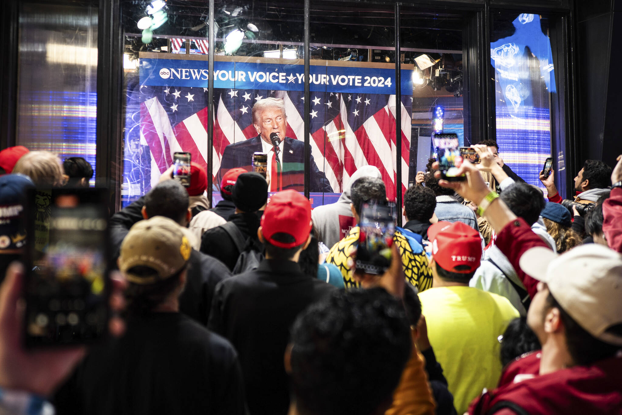 People watch a broadcast of Former President Donald Trump, the Republican presidential nominee, delivering a speech at Times Square in New York, on Wednesday, Nov. 6, 2024. (Graham Dickie/The New York Times)