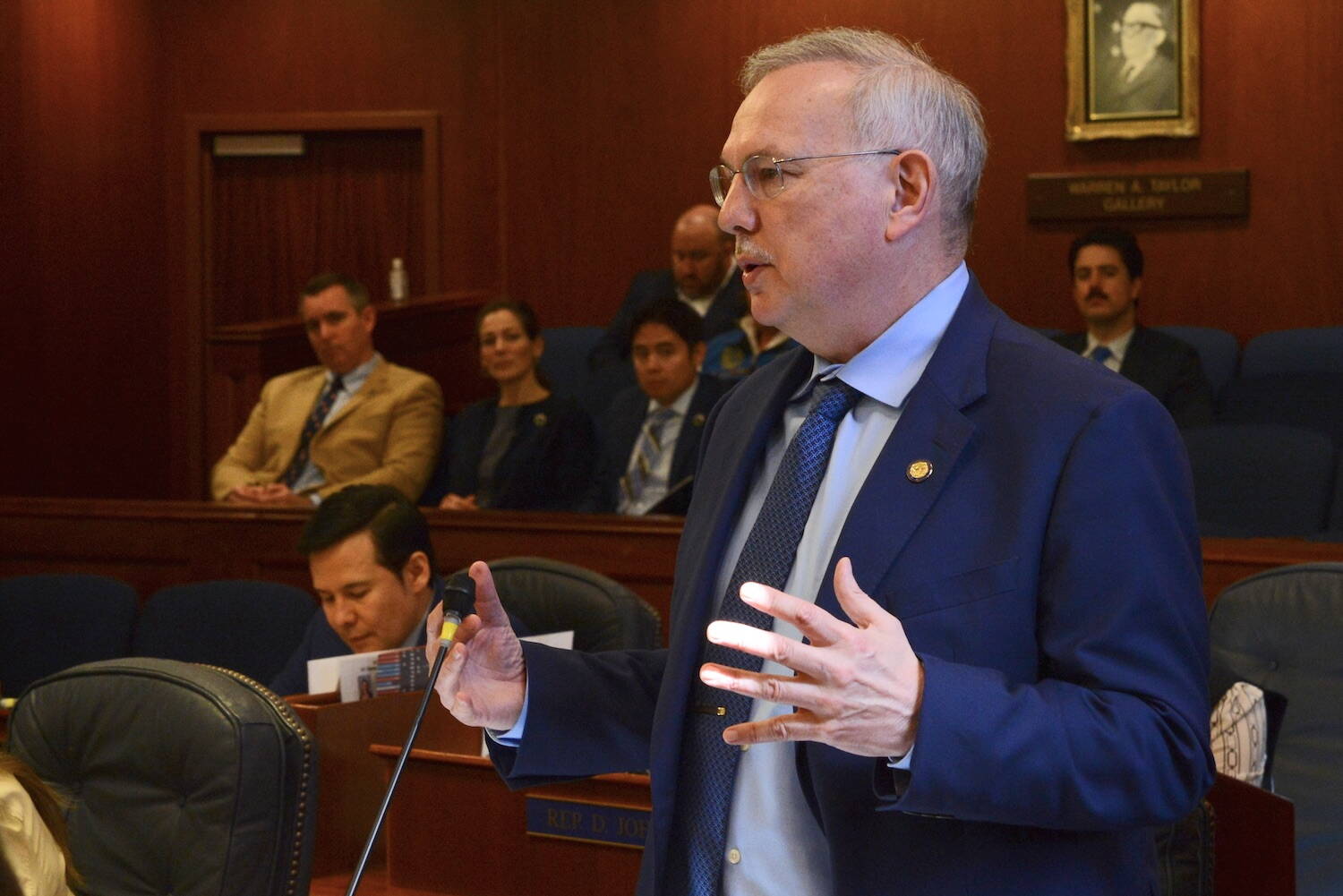 Rep. Bryce Edgmon, I-Dillingham, speaks in favor of Senate Bill 48, the carbon credits bill, on Tuesday, May 16, 2023, in the Alaska House. At background is Department of Resources Commissioner John Boyle and staff supporting the bill. (James Brooks/Alaska Beacon)