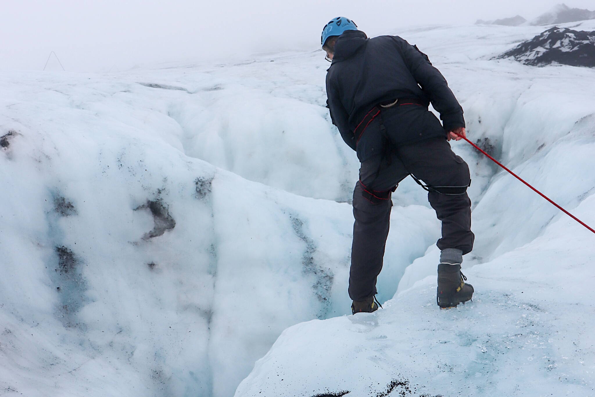 Þorsteinn Þorsteinsson looks at a moulin on the Sólheimajökull glacier on Oct. 20. A moulin, or glacier mill, is a crevasse through which water enters a glacier from the surface. (Jasz Garrett / For the Juneau Empire)