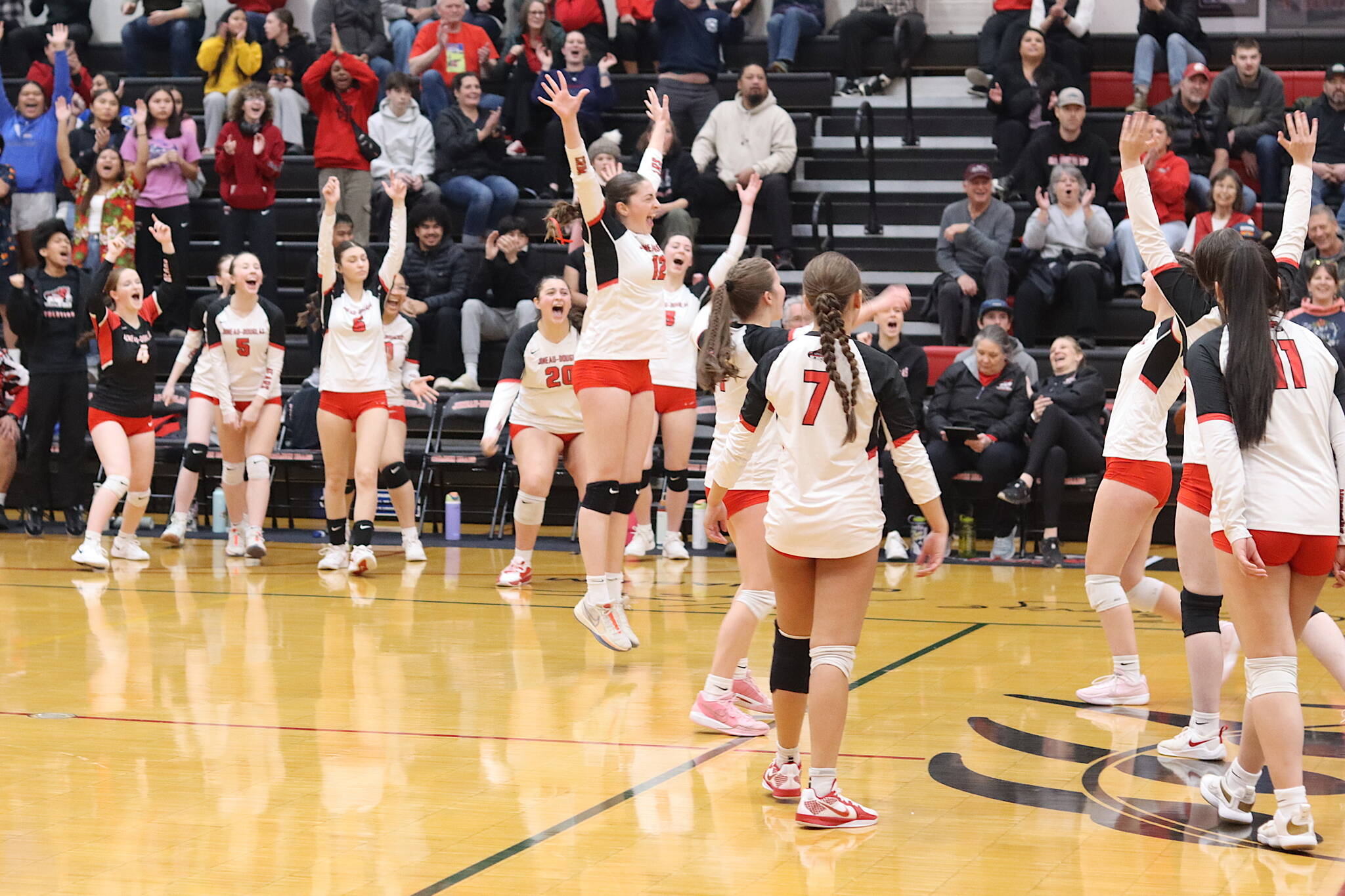 The Juneau-Douglas High School: Yadaa.at Kalé volleyball team celebrates scoring the winning point in Saturday’s game against Ketchikan High School at JDHS to win the Region V title and advance to the state tournament next week. (Mark Sabbatini / Juneau Empire)