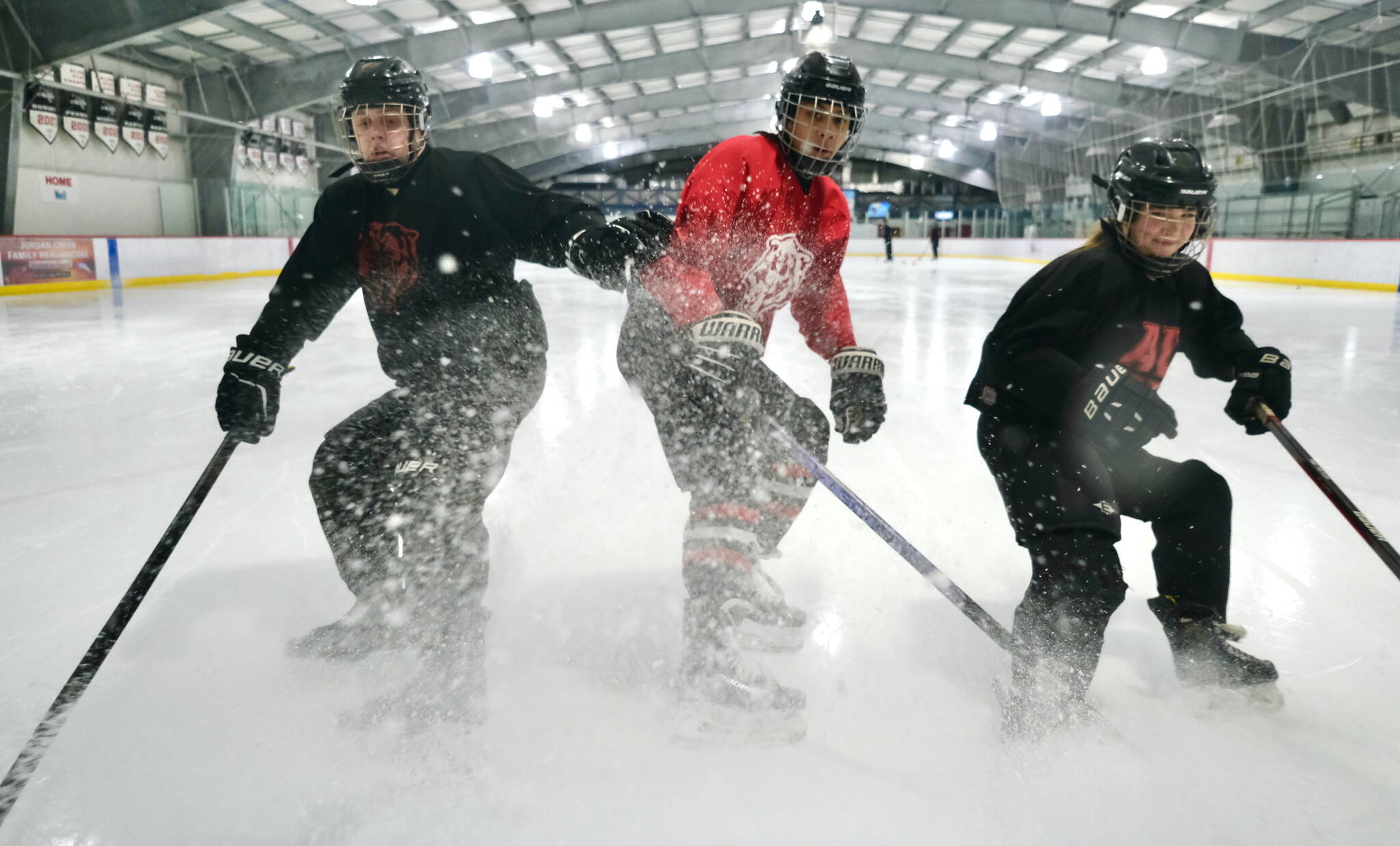 Juneau-Douglas High School: Yadaa.at Kalé junior Hunter Lingle, junior Nolan Cruz and sophomore Stahly Sheehan work the ice Wednesday at Treadwell Arena before a JDHS practice. The Crimson Bears varsity hosts the North Pole Patriots Friday at 7 p.m. and Saturday at 3 p.m. (Klas Stolpe / Juneau Empire)