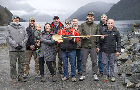 City officials pose with a gold shovel at the location of a new marine haulout Friday at the Gary Paxton Industrial Site. Pictured are, from left, Assembly member Kevin Mosher, GPIP Board of Directors members Chad Goeden and Lauren Howard Mitchell (holding her son, Gil Howard), Municipal Engineer Michael Harmon, Assembly member Thor Christianson, Municipal Administrator John Leach, Mayor Steven Eisenbeisz, Sitka Economic Development Association Executive Director Garry White, and GPIP Board of Directors Chair Scott Wagner. (James Poulson / Sitka Sentinel)