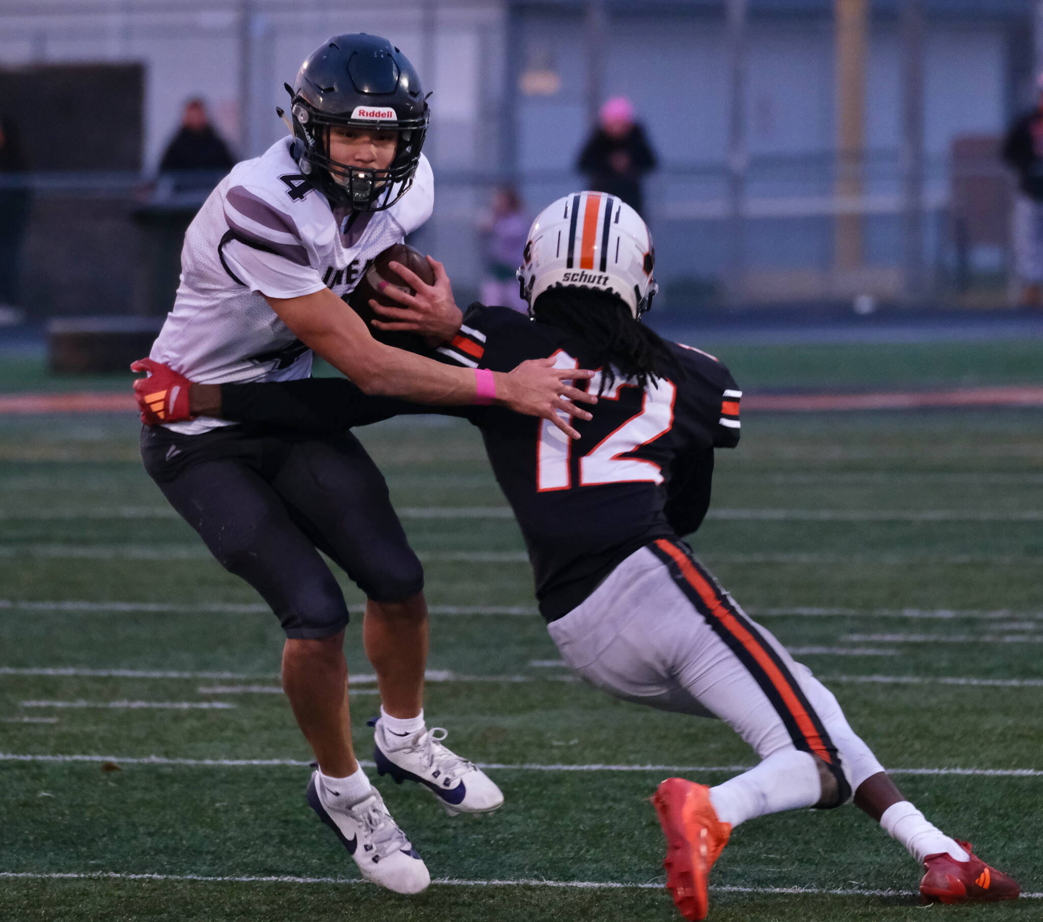 Juneau senior Jayden Johnson (4) brushes off a tackle by West Anchorage junior Talon Copeland (12) during a state playoff game at West Anchorage. Johnson was selected the All-State utility player of the year and a first-team all-state receiver. (Klas Stolpe / Juneau Empire file photo)