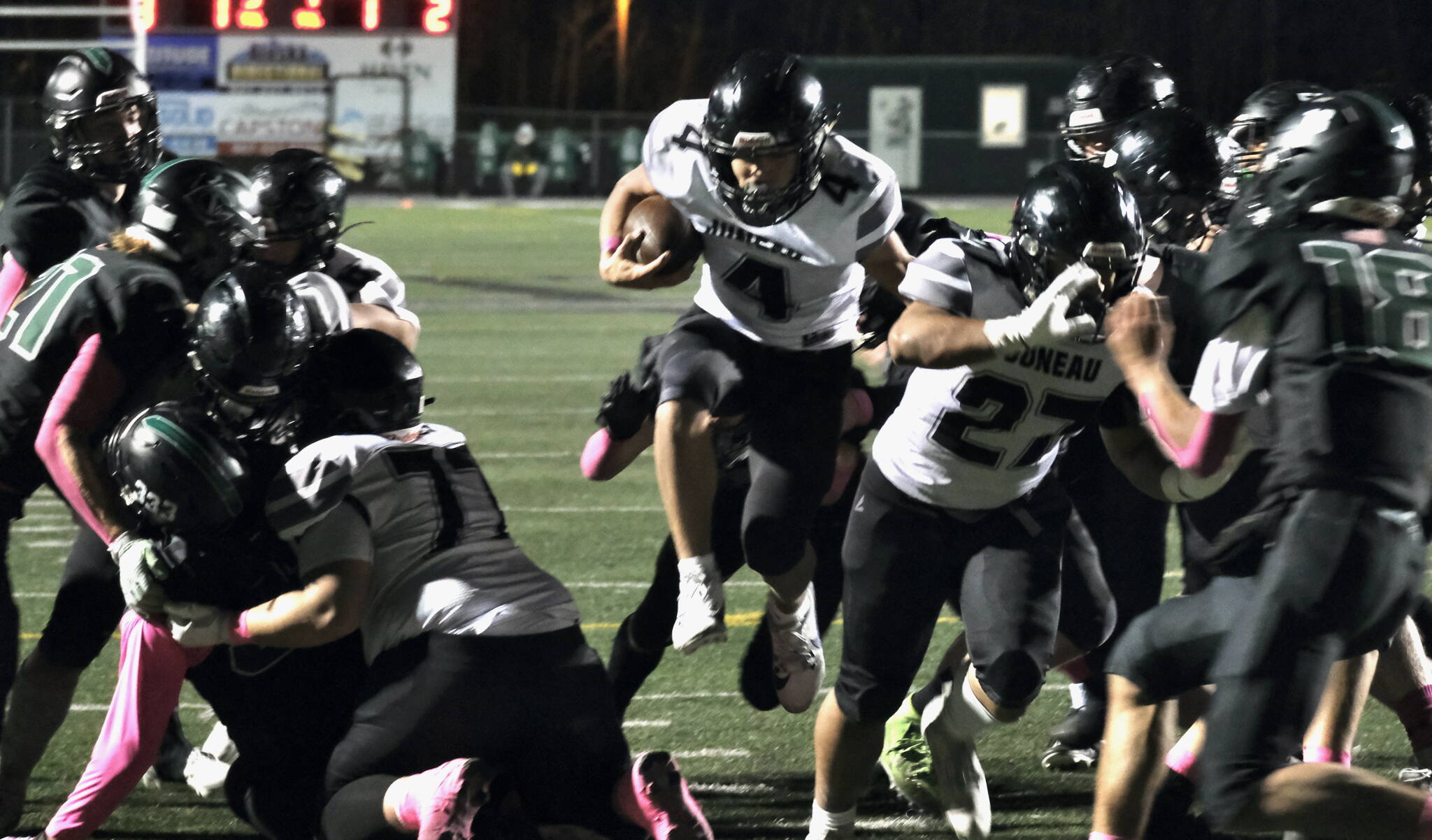 Juneau Huskies senior Jayden Johnson (4) finds a hole to run through against the Colony Knights in Palmer this season. (Klas Stolpe / Juneau Empire file photo)