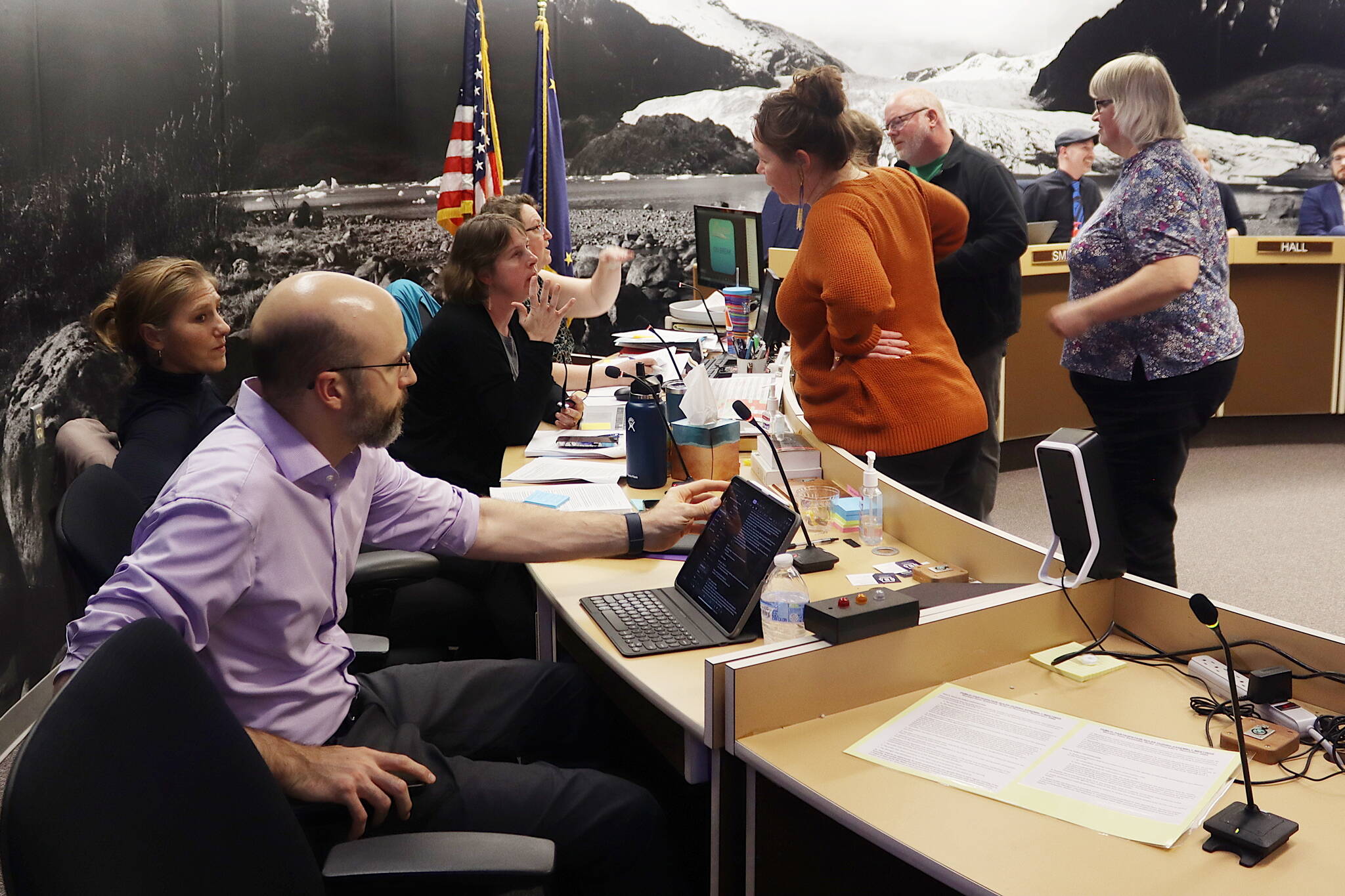 Juneau Assembly members confer with city administrative leaders about details of a proposed resolution asking the state for more alcohol licenses during an Assembly meeting Monday night. (Mark Sabbatini / Juneau Empire)