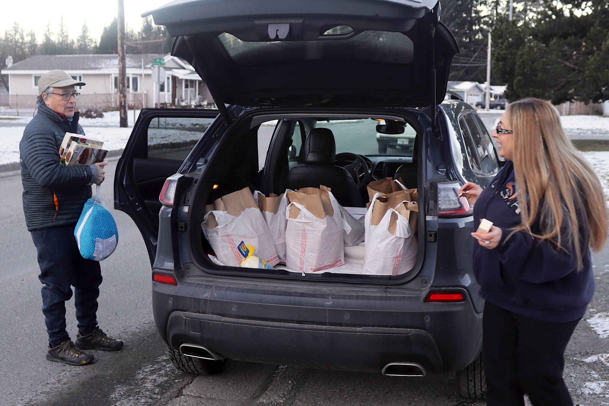 Larry Gamez and Rachel Ceja collect items for a Thanksgiving food basket to deliver to a house in the Mendenhall Valley on Saturday morning as part of St. Vincent de Paul’s annual distribution program. (Mark Sabbatini / Juneau Empire)