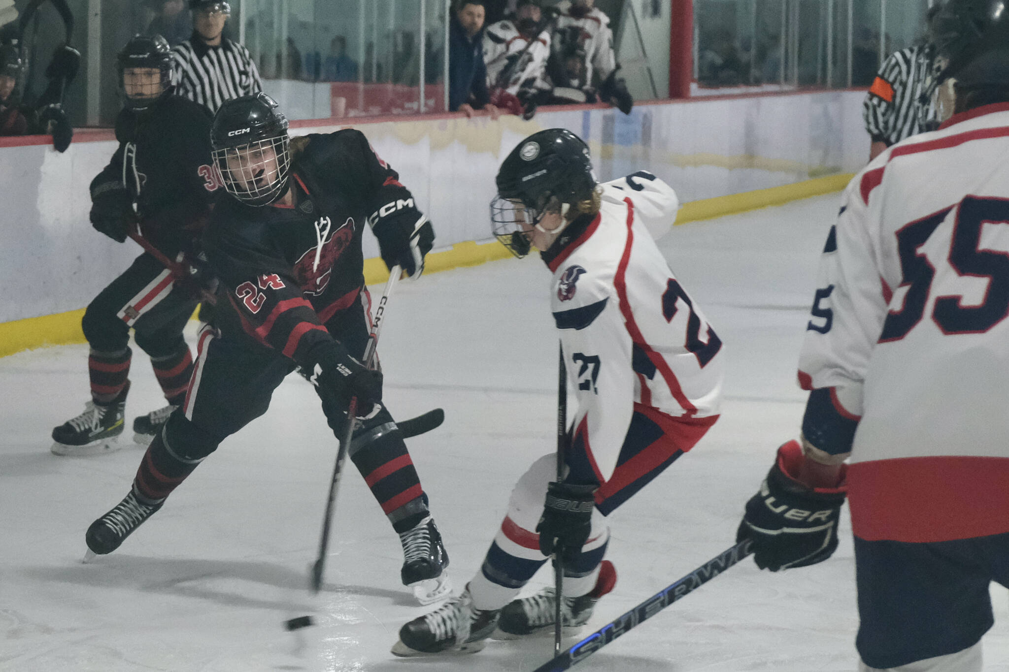 Juneau-Douglas High School: Yadaa.at Kalé junior Isaac Phelps (24) shoots a puck against North Pole in action earlier this season at Treadwell Ice Arena. Phelps had two assists against the Palmer Moose this weekend at Palmer. (Klas Stolpe / Juneau Empire file photo)