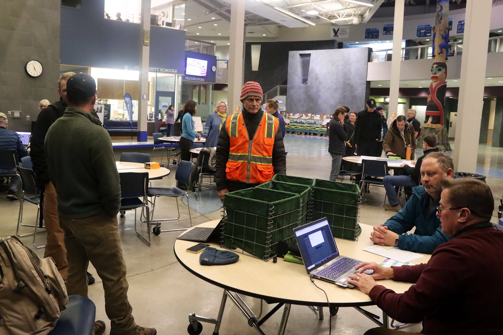 Dan Allard (right), a flood fighting expert for the U.S. Army Corps of Engineers, explains how Hesco barriers function at a table where miniature replicas of the three-foot square and four-foot high barriers are displayed during an open house Nov. 14 at Thunder Mountain Middle School to discuss flood prevention options in Juneau. (Mark Sabbatini / Juneau Empire file photo)