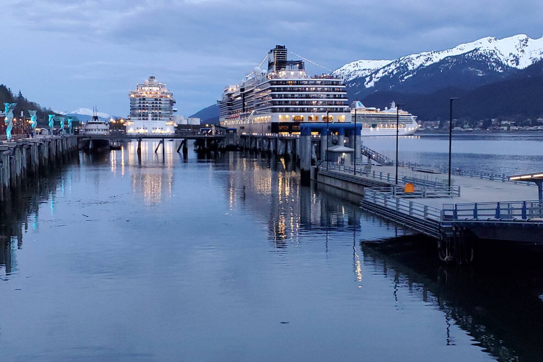 Three cruise ships are docked along Juneau’s waterfront on the evening on May 10, 2023, as a Princess cruise ship on the right is departing the capital city. A “banner” year for tourism in 2023, when a record 1.65 million cruise passengers visited the state, lifted workers’ average wages in the Southeast region, the state Department of Labor and Workforce Development reported. (Yereth Rosen/Alaska Beacon)