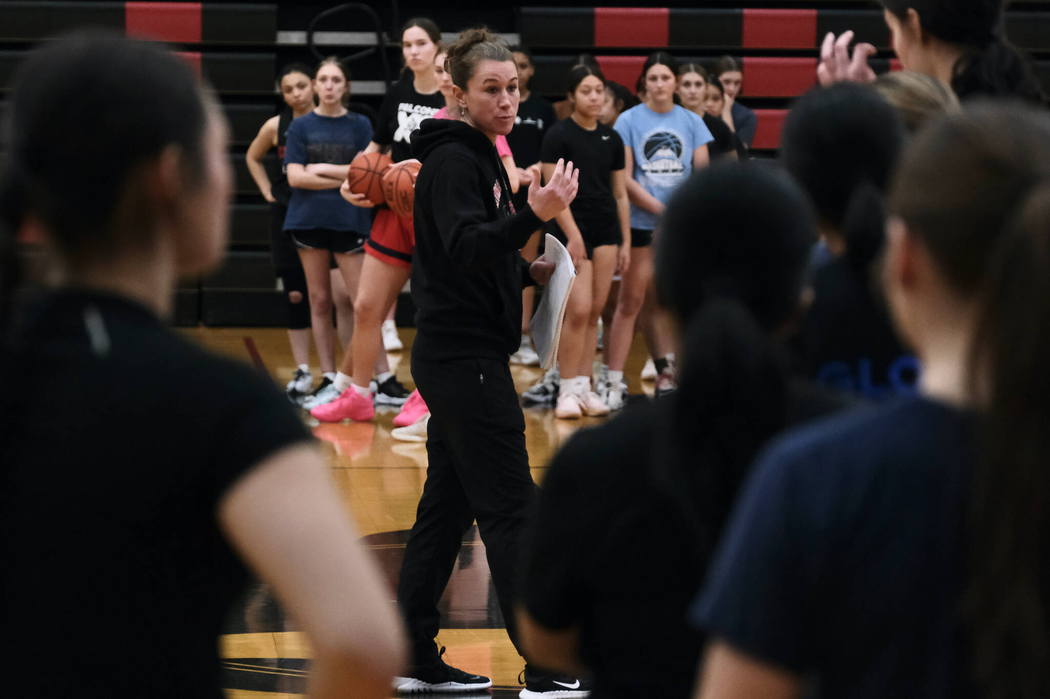 Juneau-Douglas High School: Yadaa.at Kalé girls head coach Tanya Nizich talks to Crimson Bears players during the first day of girls varsity basketball tryouts Wednesday at the George Houston Gymnasium. (Klas Stolpe / Juneau Empire)