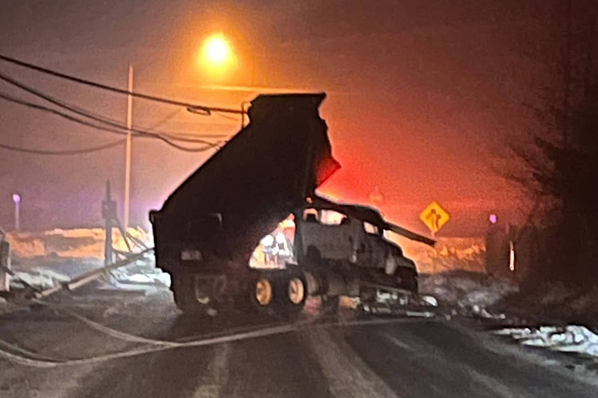 A dump truck reportedly stolen by a drunk driver is ensnared in power lines on Industrial Boulevard early Saturday morning. (Photo by Jeremy Sidney)