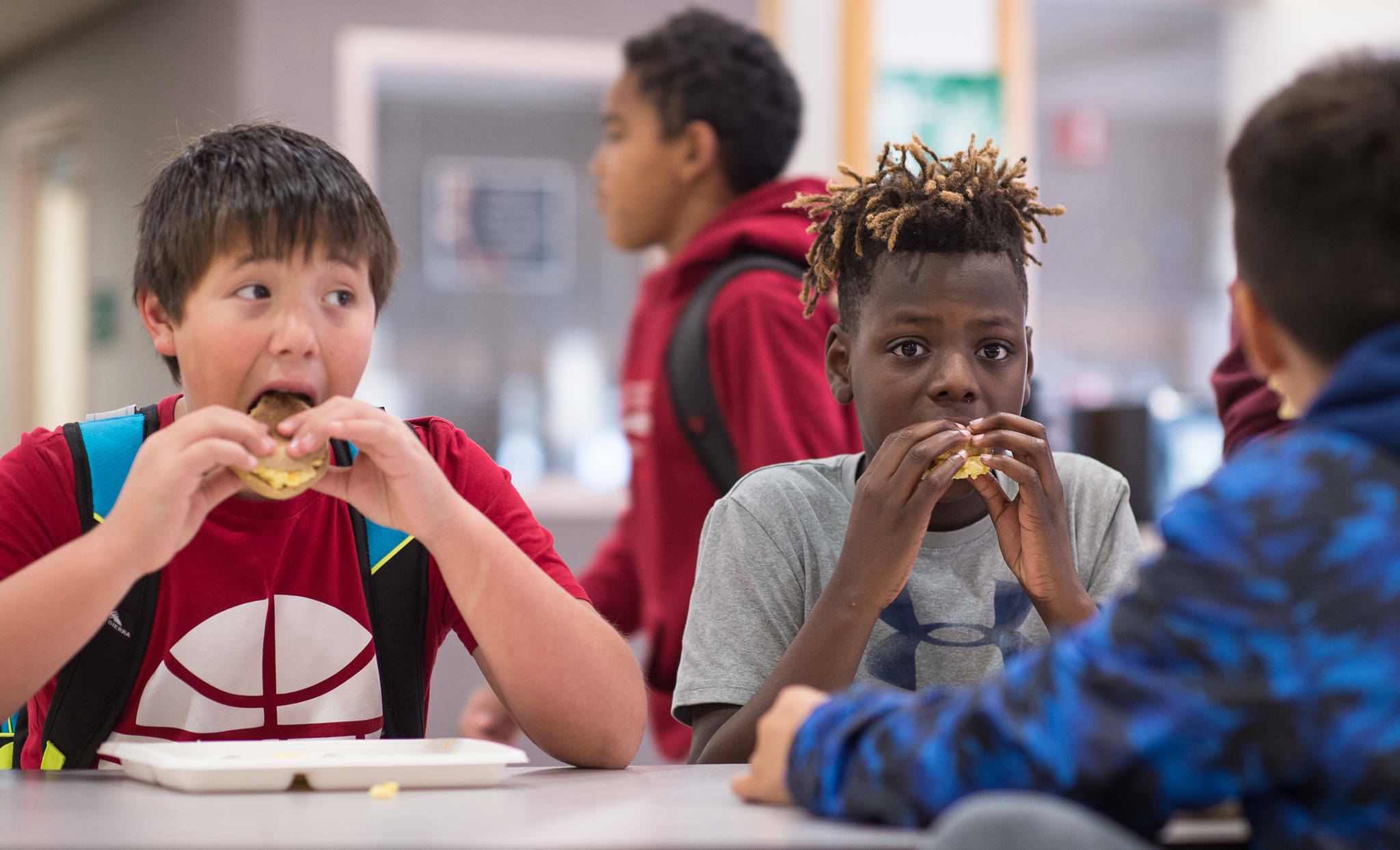 Kahyl Dybdahl, left, and Bronze Chevis eat an egg sandwich breakfast before school at Dzantik’i Heeni Middle School on Wednesday, Sept. 6, 2017. (Michael Penn / Juneau Empire file photo)