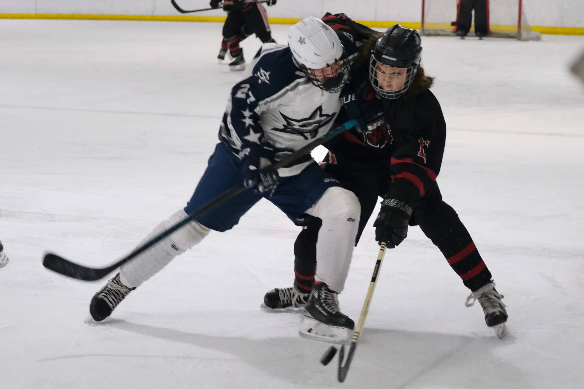 Soldotna’s Keegan Myrick and Juneau-Douglas High School: Yadaa.at Kalé sophomore Caden Morris battle for a puck during Friday’s 4-3 Crimson Bears’ loss to the visiting Stars at Treadwell Ice Arena. (Klas Stolpe / Juneau Empire)