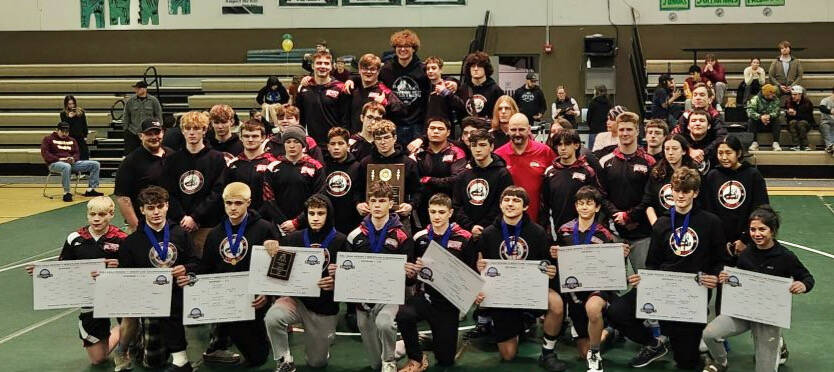 The Juneau-Douglas High School: Yadaa.at Kalé wrestling team pose with their ASAA Southeast Region V Championship titles and trophies Saturday at Haines. (Photo courtesy Crimson Bears)