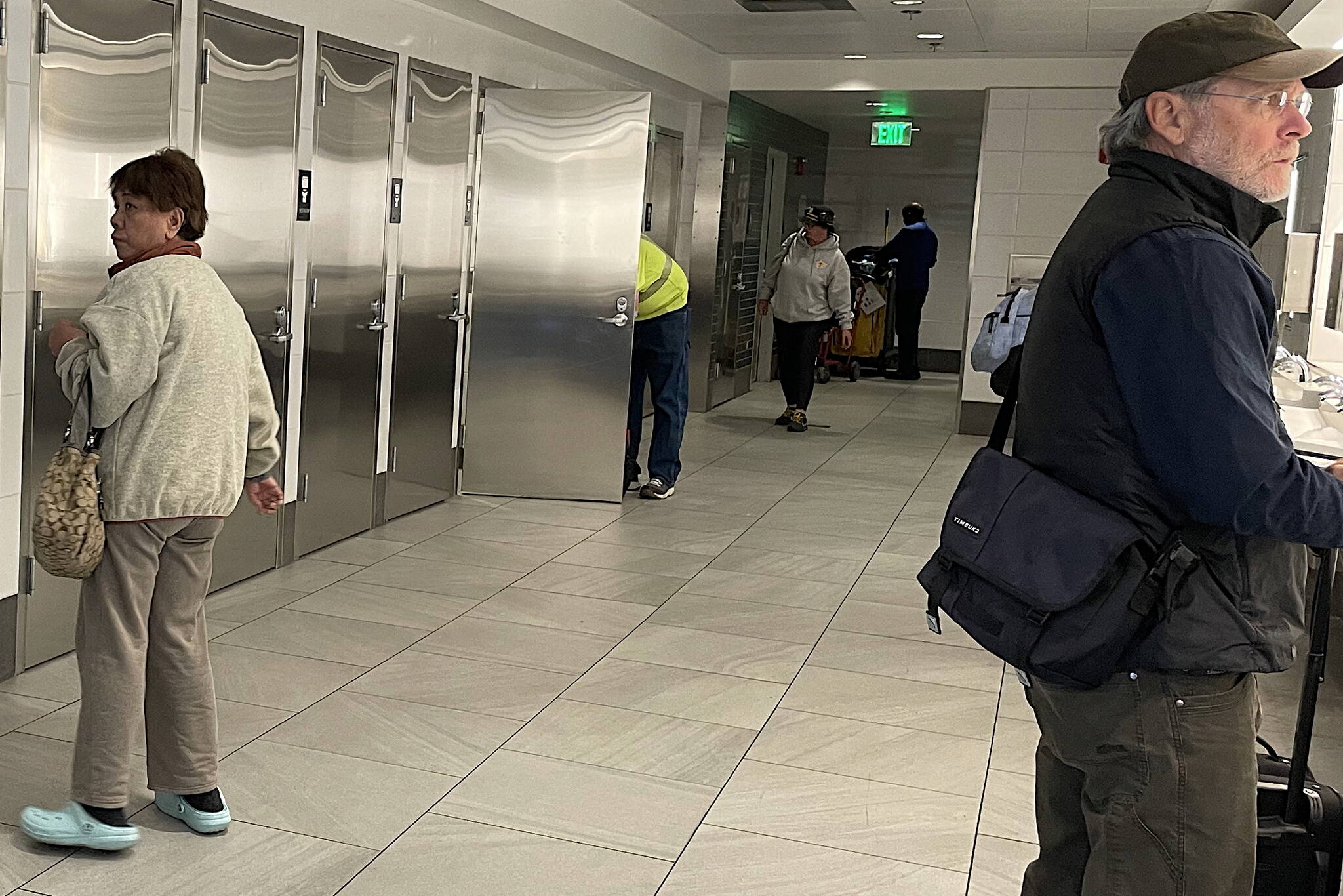 Travelers using the all-gender restroom at Seattle–Tacoma International Airport on Dec. 3. (Laurie Craig / Juneau Empire)