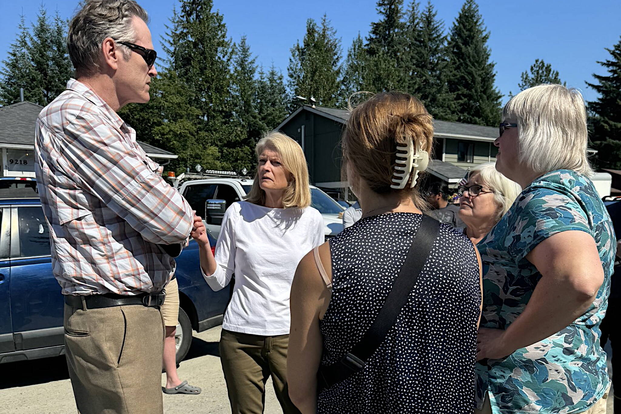 Gov. Mike Dunleavy (left) talks with U.S. Sen. Lisa Murkowski and local leaders during an Aug. 7 visit to a Mendenhall Valley neighborhood hit by record flooding. (Photo provided by U.S. Sen. Lisa Murkowski’s office)