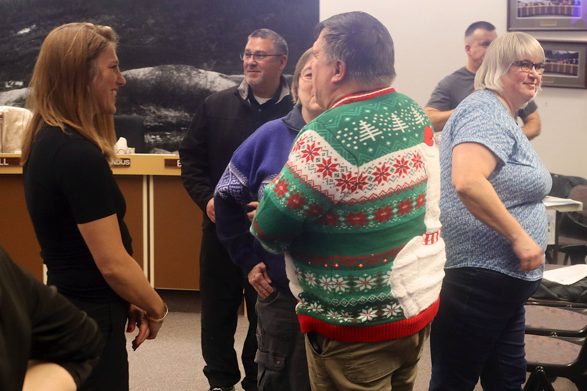 Juneau City Manager Katie Koester (left) and Mayor Beth Weldon (right) meet with residents affected by glacial outburst flooding during a break in a Juneau Assembly meeting Monday night at City Hall. (Mark Sabbatini / Juneau Empire)