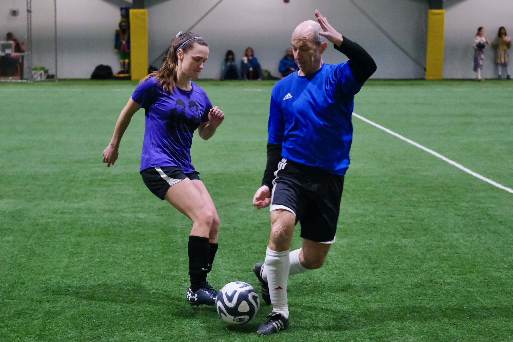 The Wet Bandits’ Shannon Hendricks and the Nutcrackers’ Kyle Hebert play a ball during the opening night of the Holiday Cup soccer tournament at the Dimond Park Field House on Wednesday. The 32nd annual holiday tournament runs through Dec. 31. (Klas Stolpe / Juneau Empire)