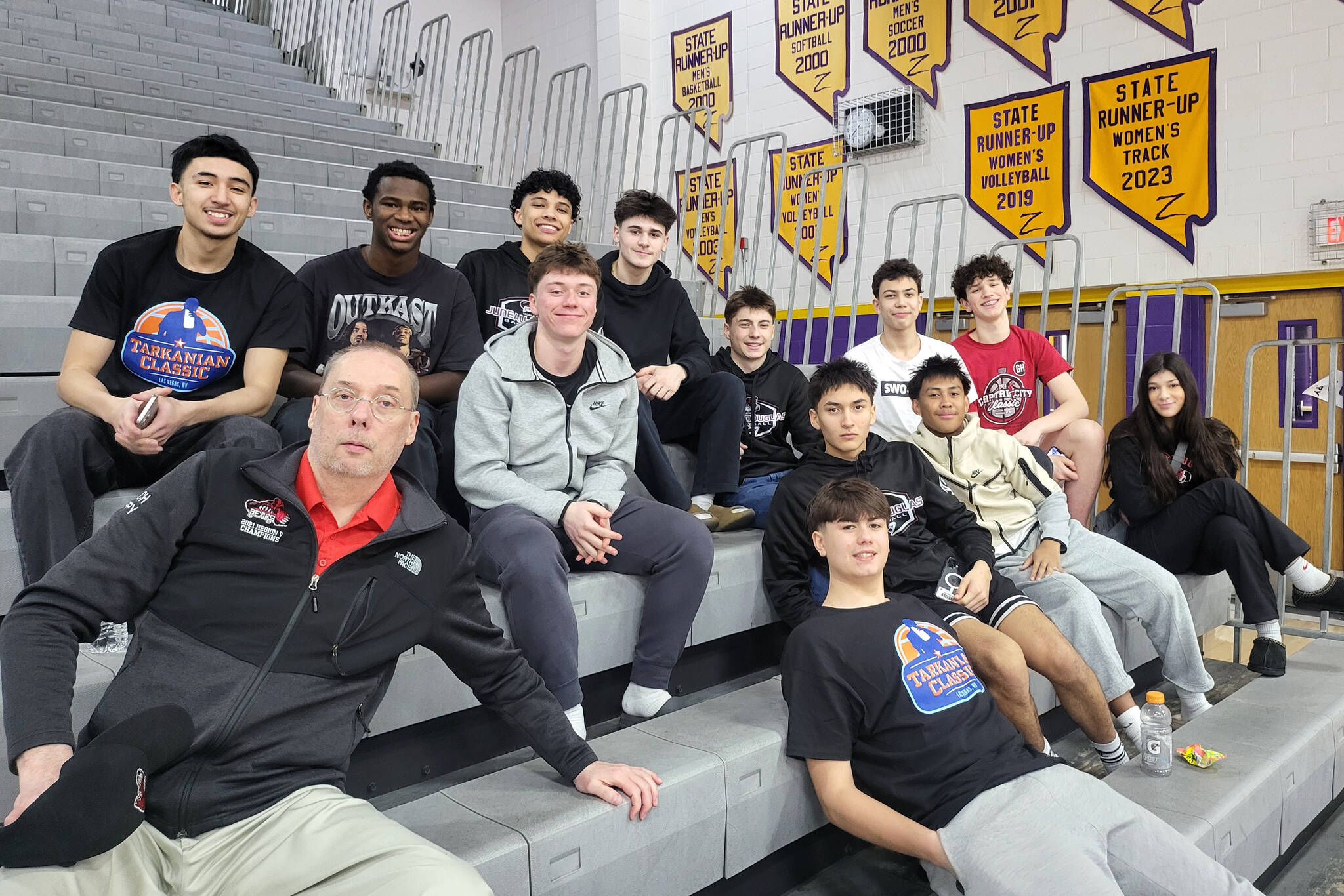 The Juneau-Douglas High School: Yadaa.at Kalé Crimson Bears boys basketball team pose in the bleachers at Durango High School in Las Vegas during the Tarkanian Classic Tournament. (Photo courtesy JDHS Crimson Bears)