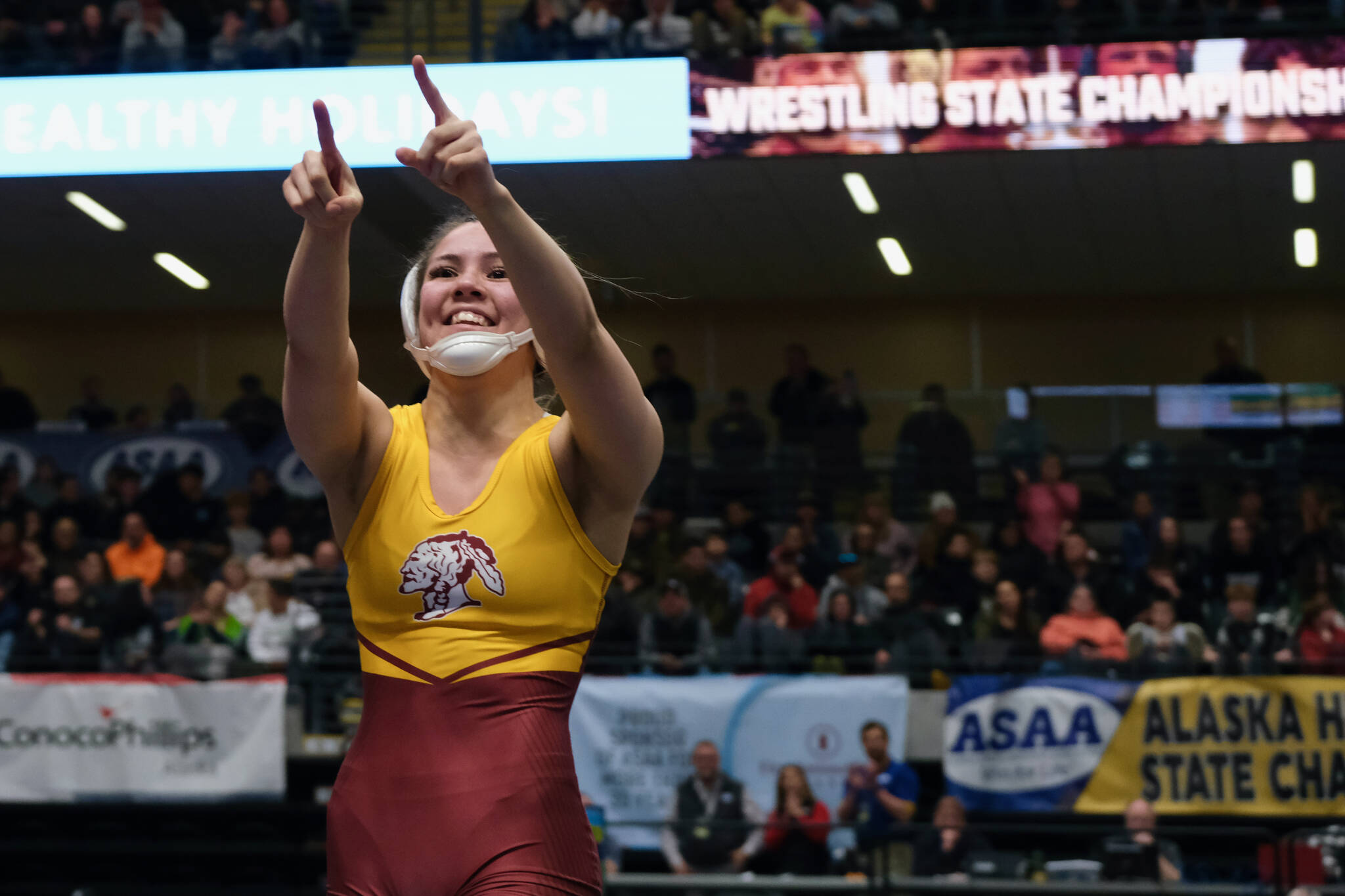 Hoonah senior Krista Howland points to the crowd after pinning Soldotna’s Rowan Peck in the girls 126-pound title match during the 2024 ASAA/First National Bank Alaska Wrestling State Championships on Saturday at Anchorage’s Alaska Airlines Center. (Klas Stolpe / Juneau Empire)