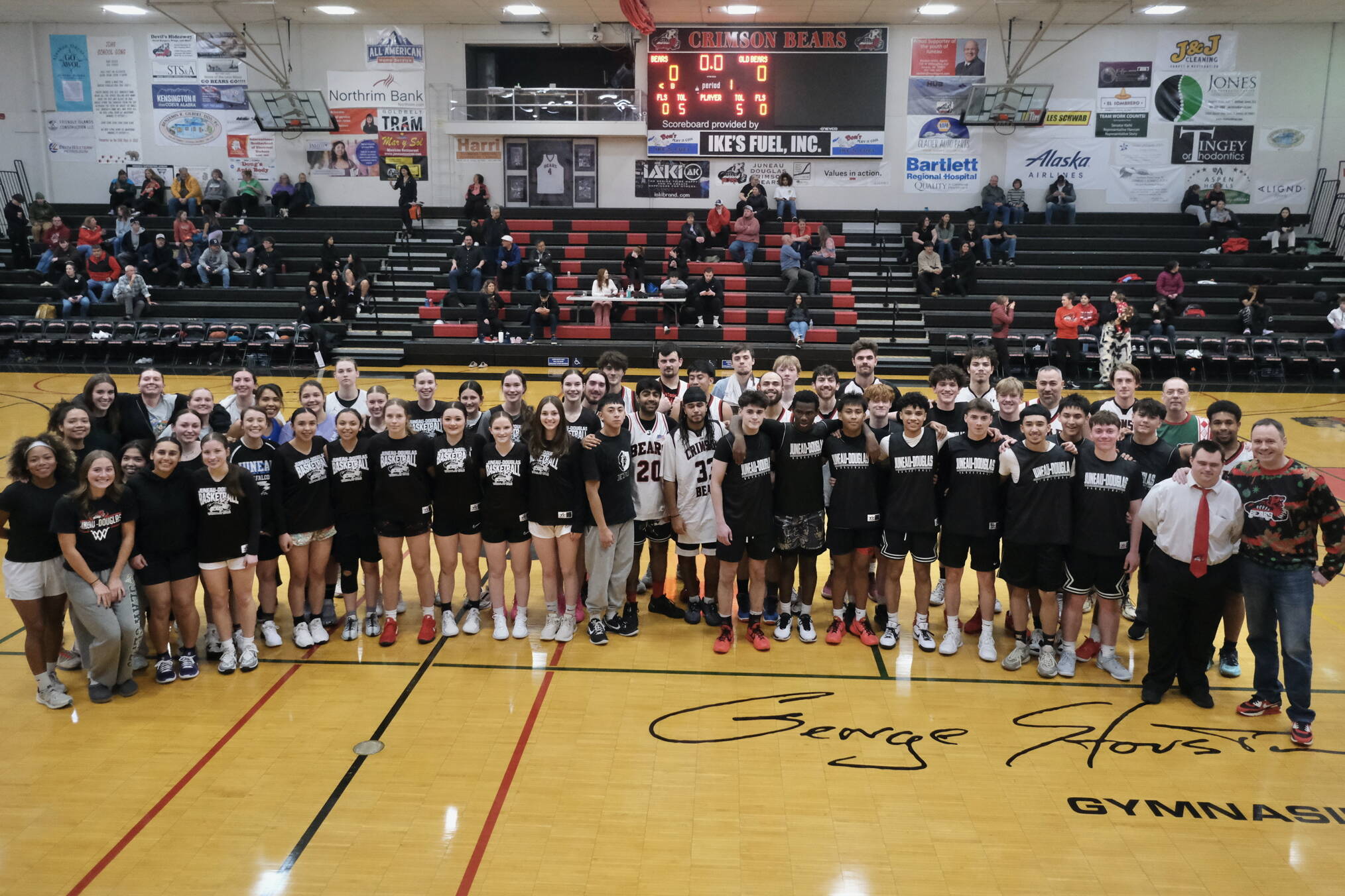 The Juneau-Douglas High School: Yadaa.at Kalé Crimson Bears varsity girls and boys basketball teams pose with alumni players during alumni games Monday at the George Houston Gymnasium. (Klas Stolpe / Juneau Empire)