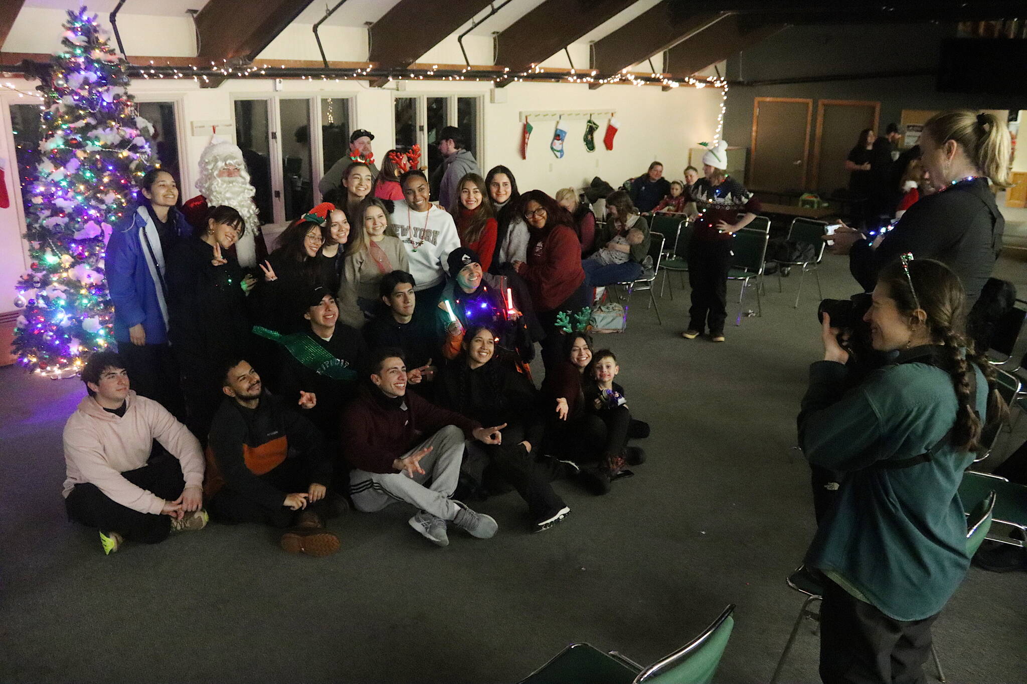 Eaglecrest Ski Area employees from Central and South America who participating in the J-1 student visa program pose for a picture with Santa during the resort’s annual Christmas Eve Torchlight Parade gathering on Tuesday. (Mark Sabbatini / Juneau Empire)