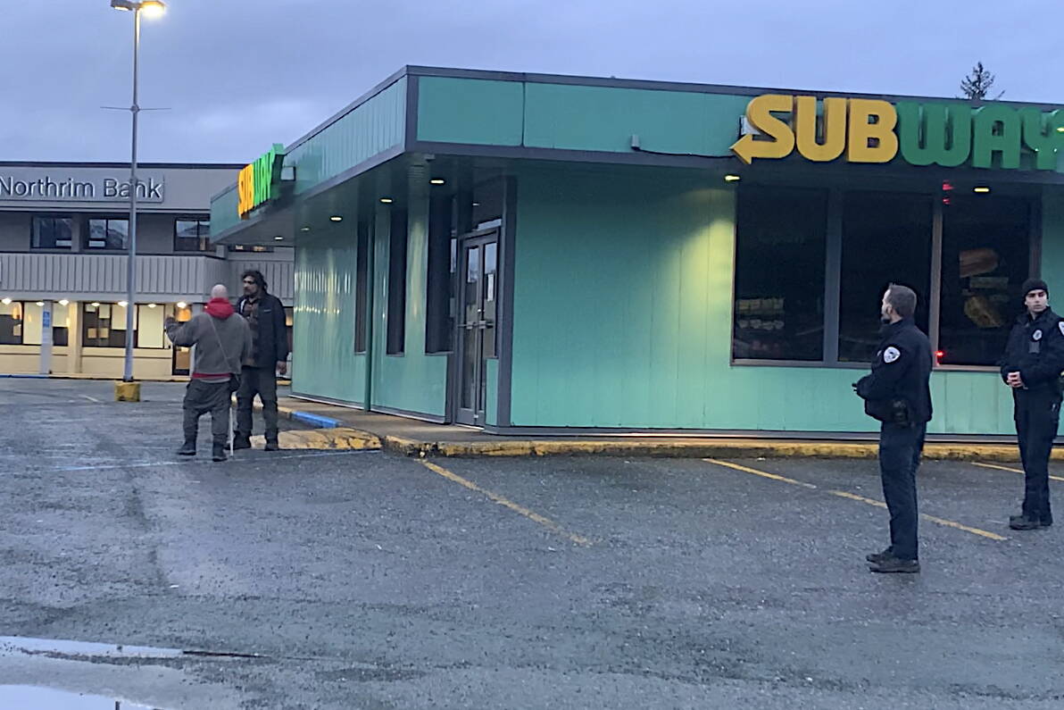 Berton Tullis (wearing a black jacket at left) greets a man who got into an angry discussion with Juneau Police Department officers following the fatal shooting of a woman by an officer near the Nugget Mall on Wednesday morning. Both men left the scene peacefully. (Mark Sabbatini / Juneau Empire)