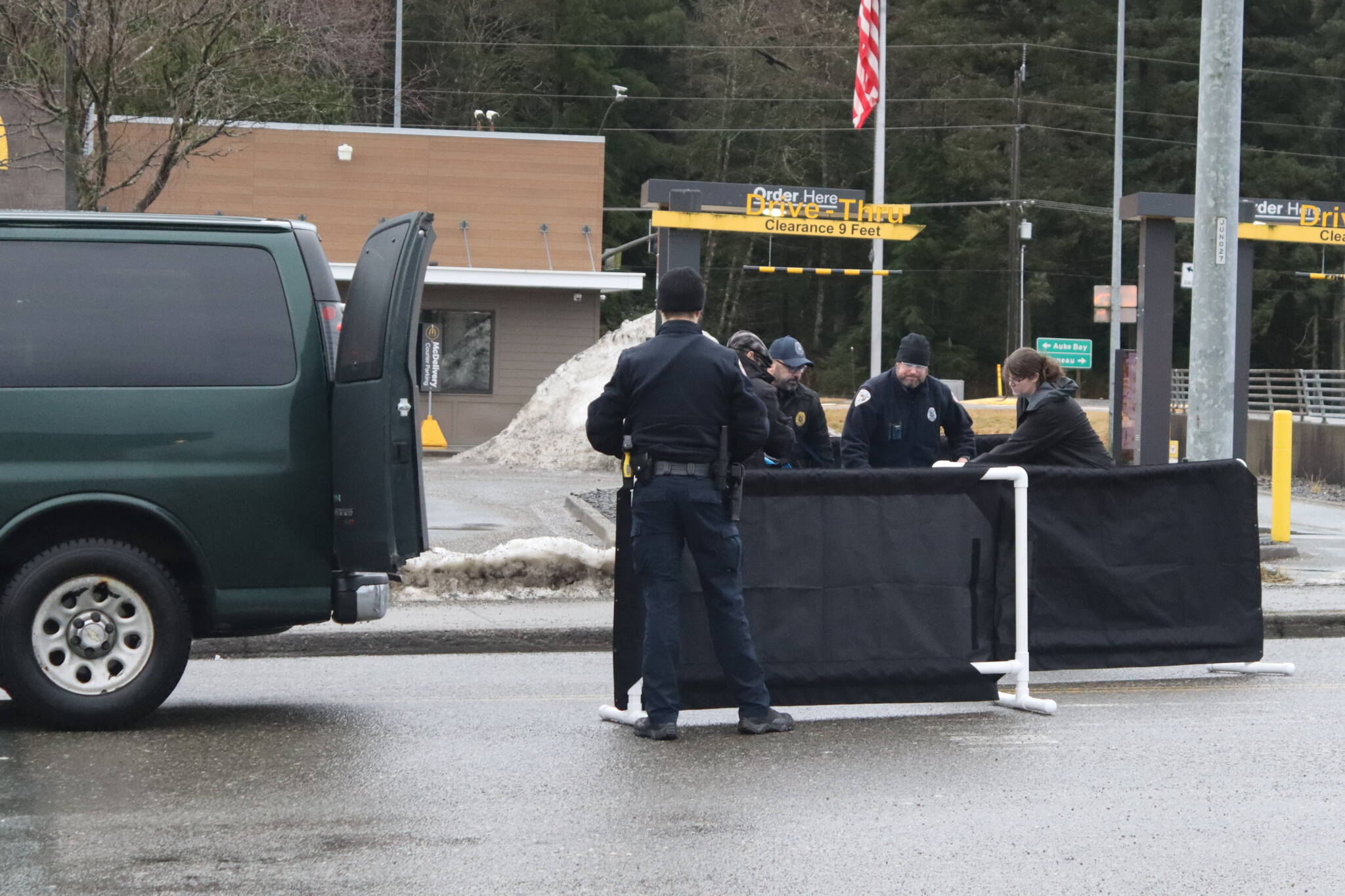 Officials prepare to move Ashley Rae Johnston from the street where she was fatally shot by police on Wednesday near the Mendenhall Valley Breeze In. (Mark Sabbatini / Juneau Empire)