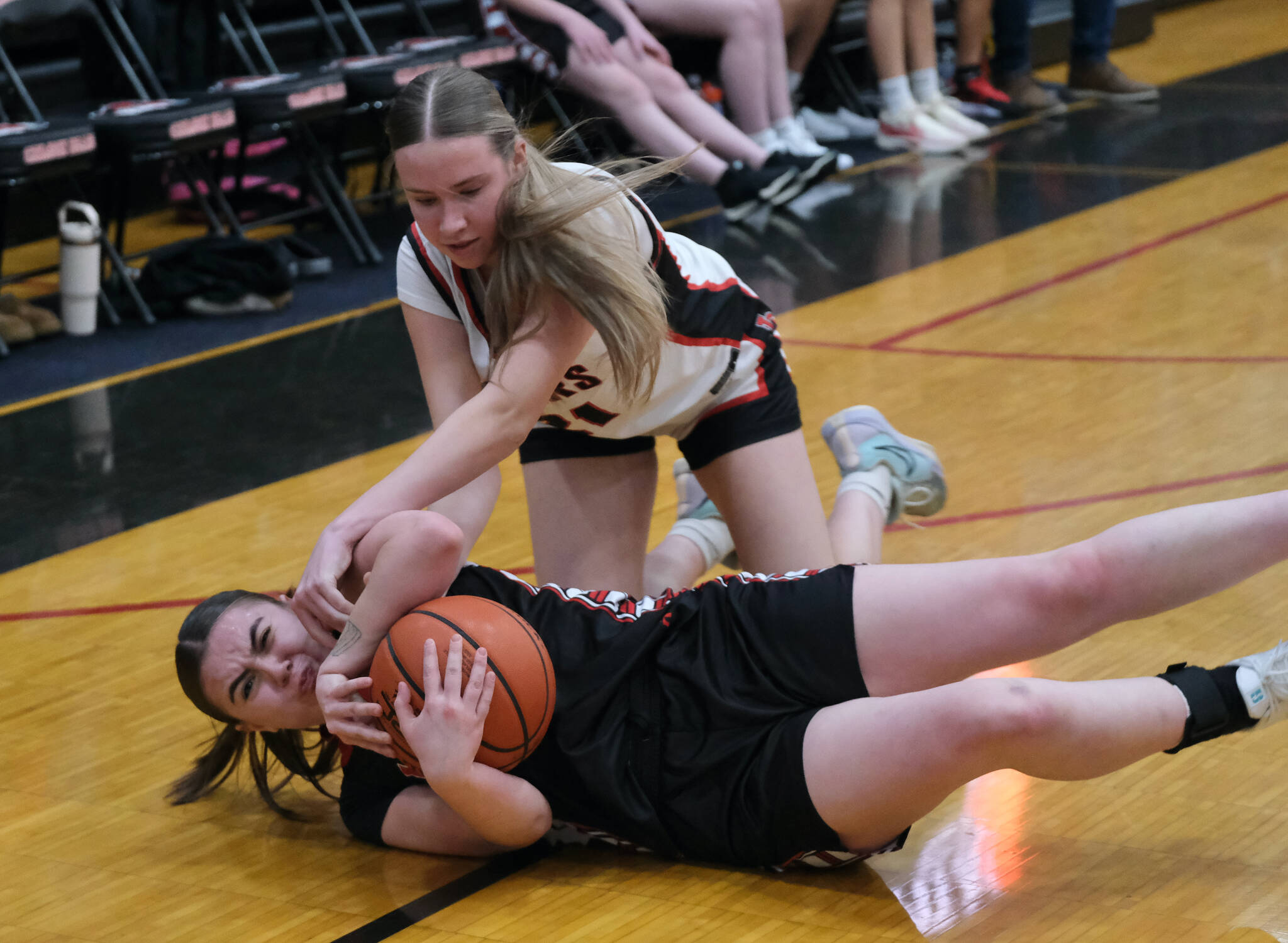 Juneau-Douglas High School: Yadaa.at Kalé Crimson Bears freshman Athena Warr (21) battles for a loose ball with Klawock senior Lea Armour during the Crimson Bears 71-21 win over the Chieftains on the opening day of the George Houston Capital City Classic on Friday in Juneau. (Klas Stolpe / Juneau Empire)