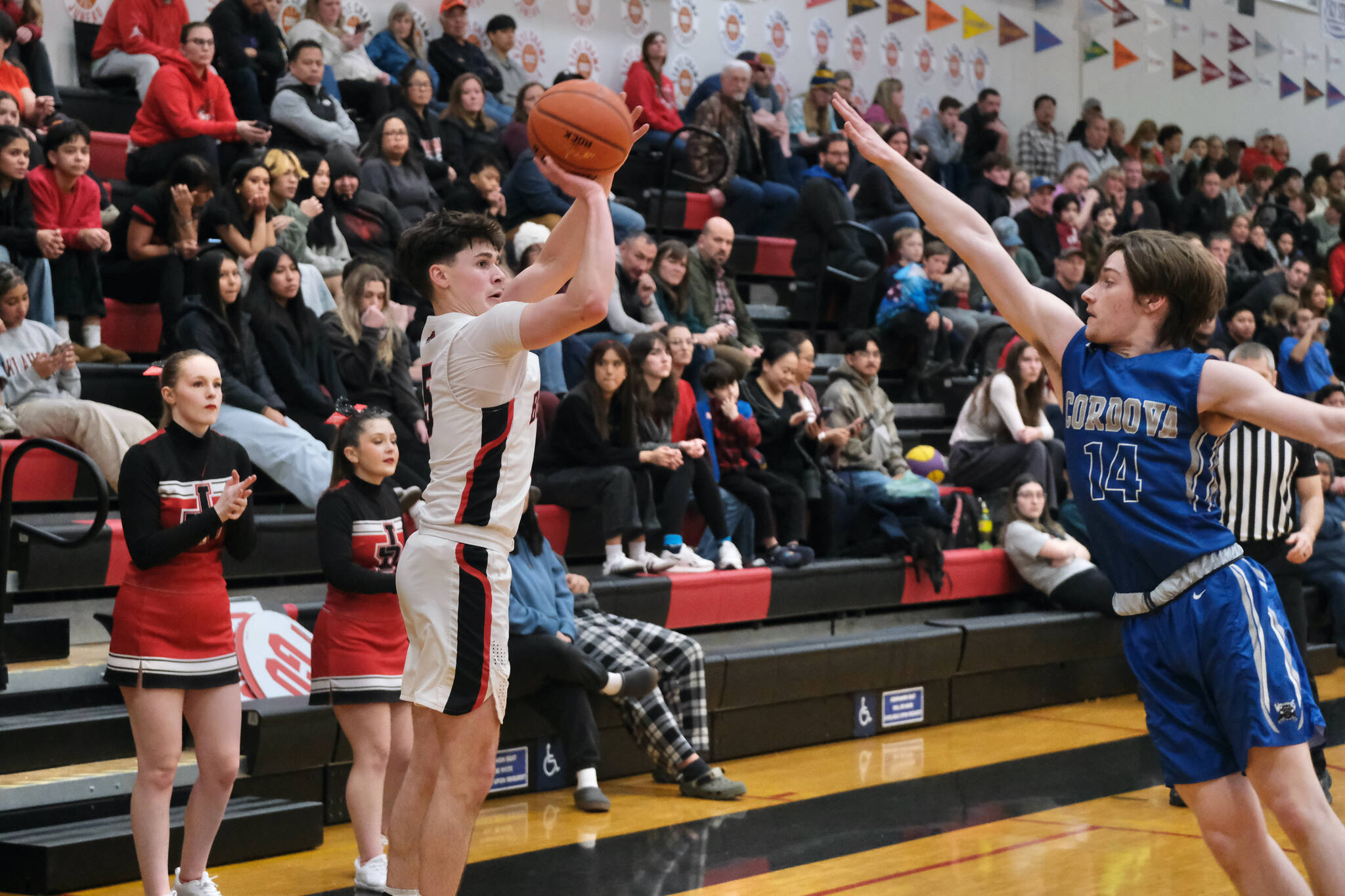 Juneau-Douglas High School: Yadaa.at Kalé junior Brandon Casperson hits a three-point shot over Cordova senior Noah Pearson (14) during the Crimson Bears 62-39 win over the Wolverines in the nightcap game of the opening day of the George Houston Capital City Classic on Friday in Juneau. (Klas Stolpe / Juneau Empire)