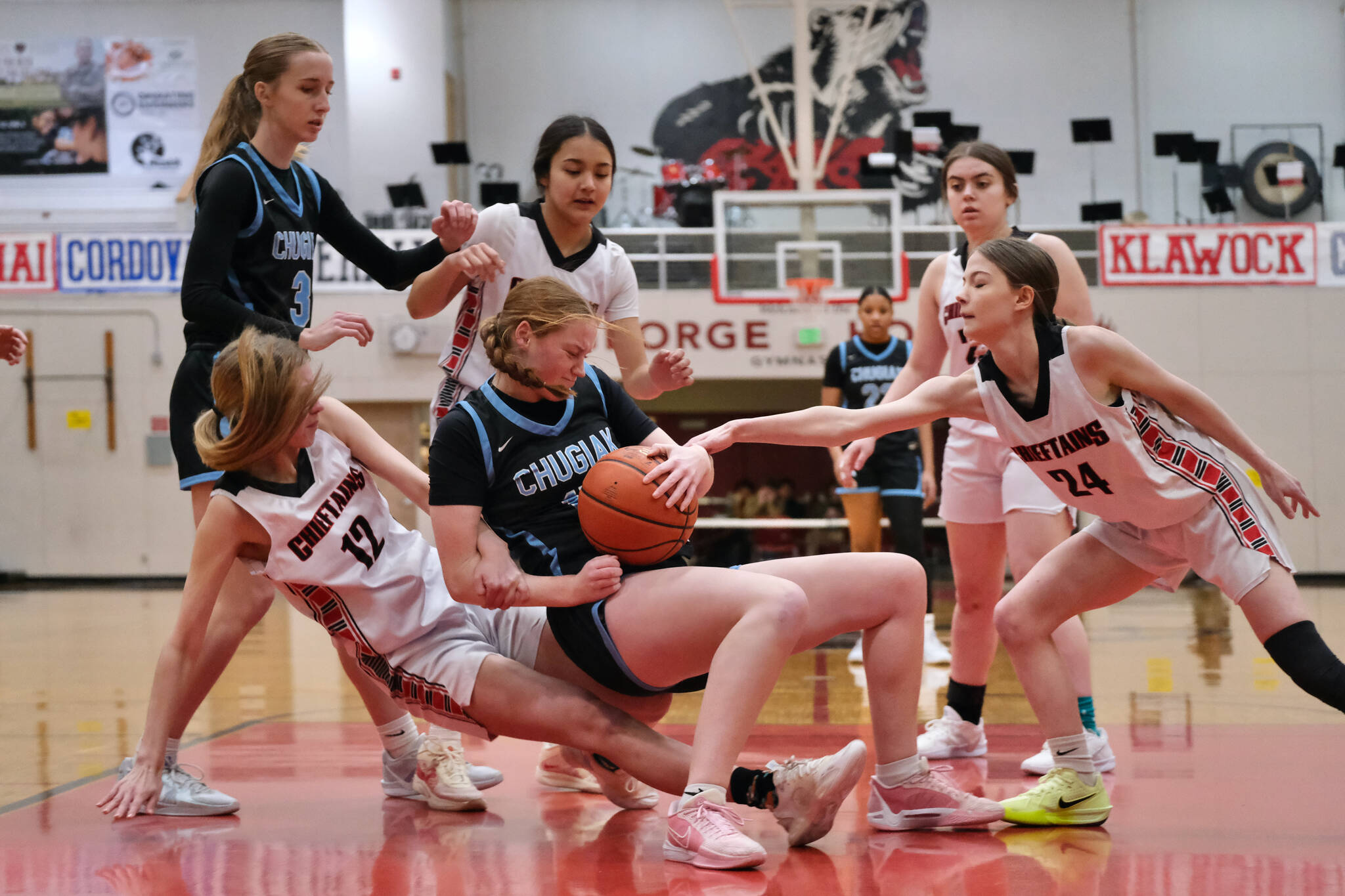 Chugiak senior Emily Desmond secures a rebound as Klawock senior Kaiya Marvin (12) and junior Taylor White (24) go for the ball in the Mustangs 45-25 win over the Chieftains during Saturday action at the George Houston Capital City Classic in Juneau. Chugiak freshman Kaitylyn Farr (3) and Klawock eighth grader Jayla Edenshaw and senior Lea Armour look on.(Klas Stolpe / Juneau Empire)