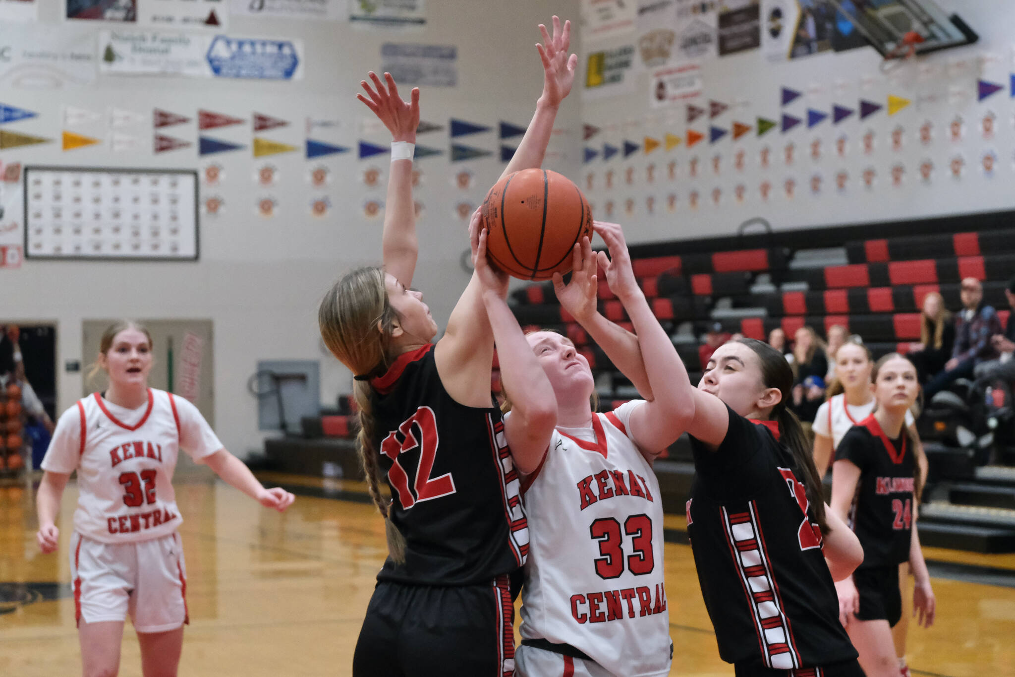 Kenai junior Ellsi Miller (33) attempts a shot against Klawock seniors Kaiya Marvin (12) and Lea Armour in the Cardinals 45-27 win over the Chieftains during Sunday action at the George Houston Capital City Classic Friday in Juneau. (Klas Stolpe / Juneau Empire)