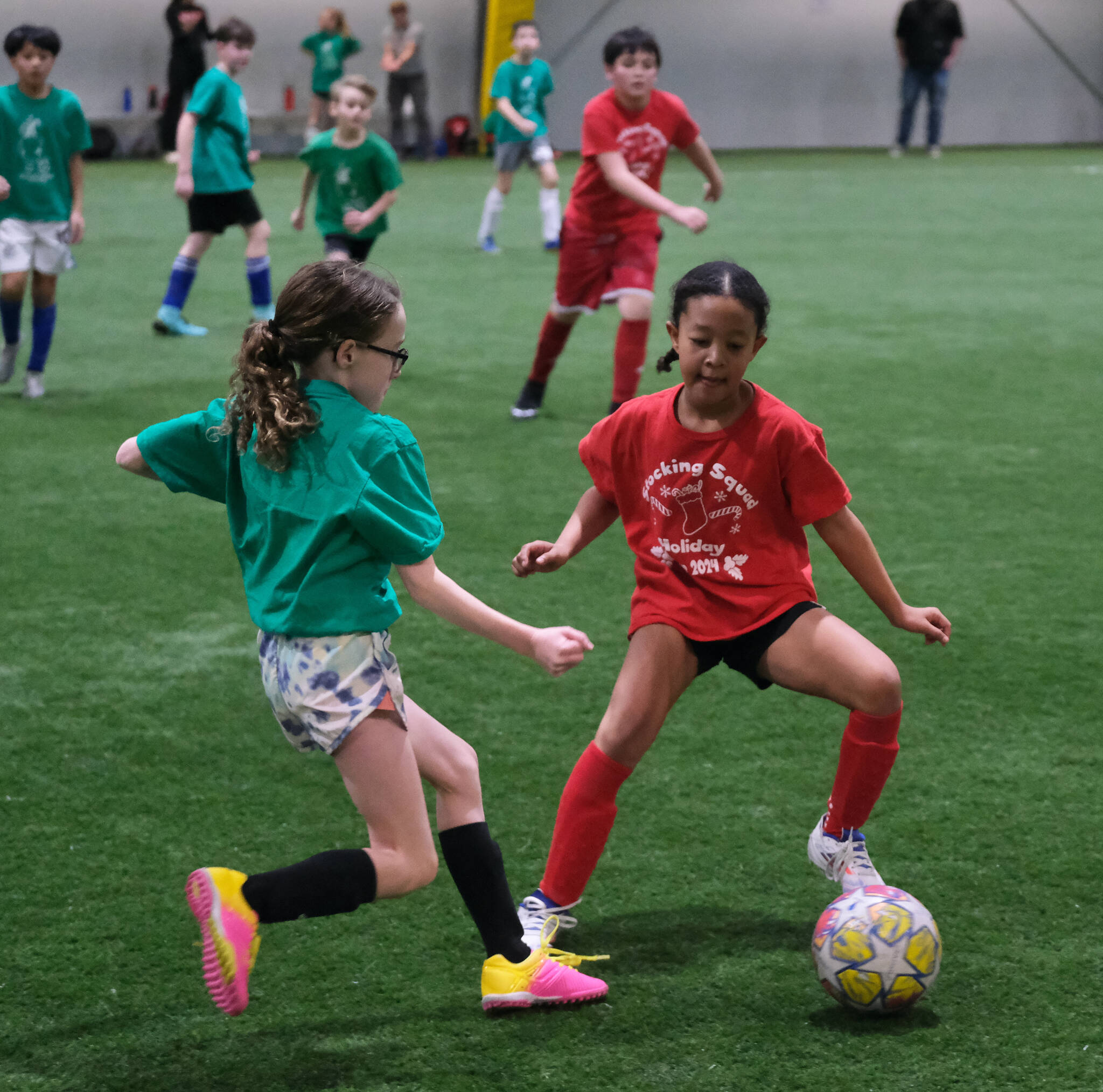 Players from the Jolly Jugglers and Stocking Squad play a ball during the Holiday Cup elementary school semifinals Monday at Dimond Park Field House. Finals for all divisions are on Tuesday. (Klas Stolpe / Juneau Empire)