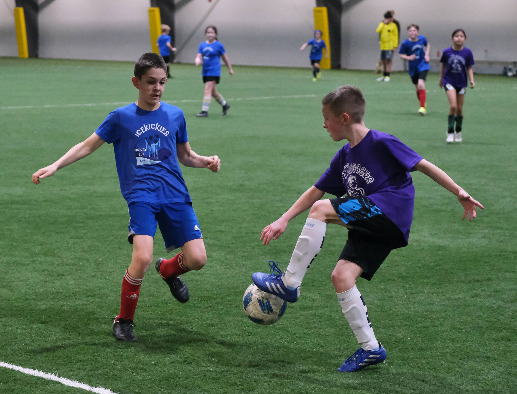 Players from the IceKickles and Nutmeggers play a ball during the Holiday Cup elementary school semifinals Monday at Dimond Park Field House. Finals for all divisions are on Tuesday. (Klas Stolpe / Juneau Empire)