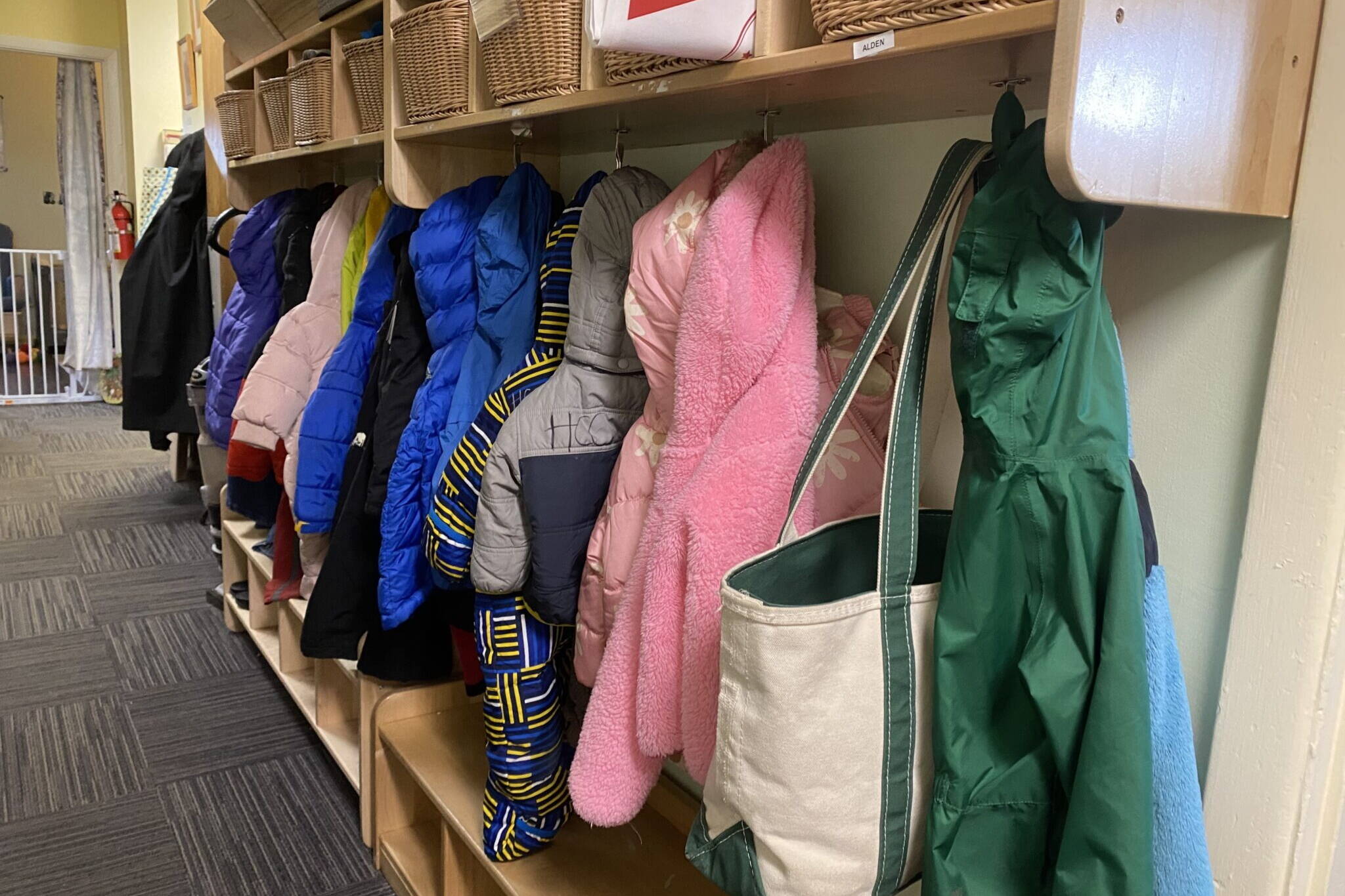 Children’s coats hang in a hallway at Hillcrest Childcare Center in Anchorage o n April 18. The second and final report of a child care task force holds recommendations for expanding subsidies that families receive, speeding the caregiver licensing and hiring process and other steps intended to address the state’s shortage of affordable child care. (Claire Stremple/Alaska Beacon)