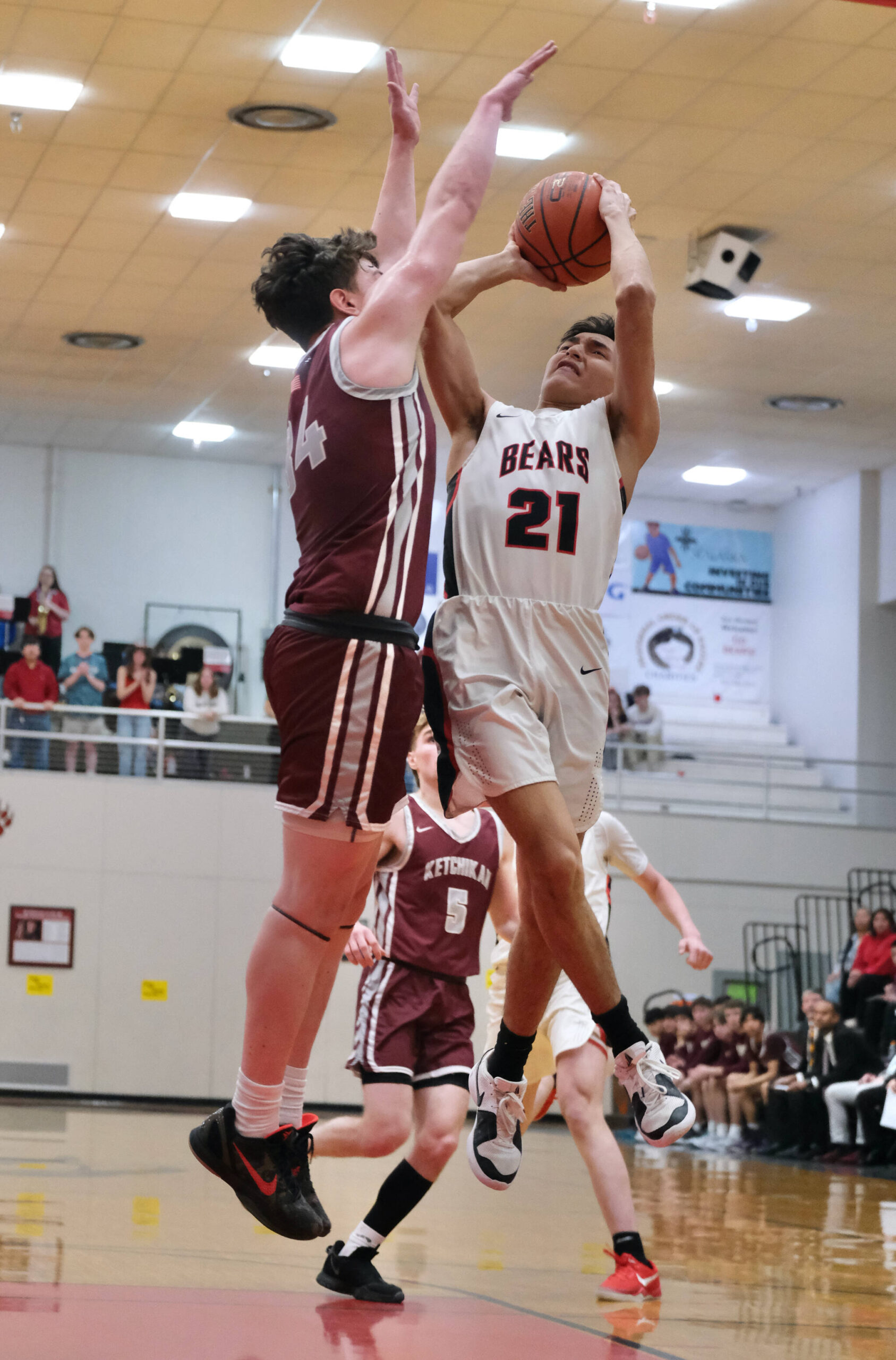 Ketchikan senior Marcus Stockhausen (34) defends a shot by Juneau-Douglas High School: Yadaa.at Kalé junior Tyler Frisby (21) during the Kings 52-48 win over the Crimson Bears on Friday at the George Houston Gymnasium in Juneau. (Klas Stolpe / Juneau Empire)